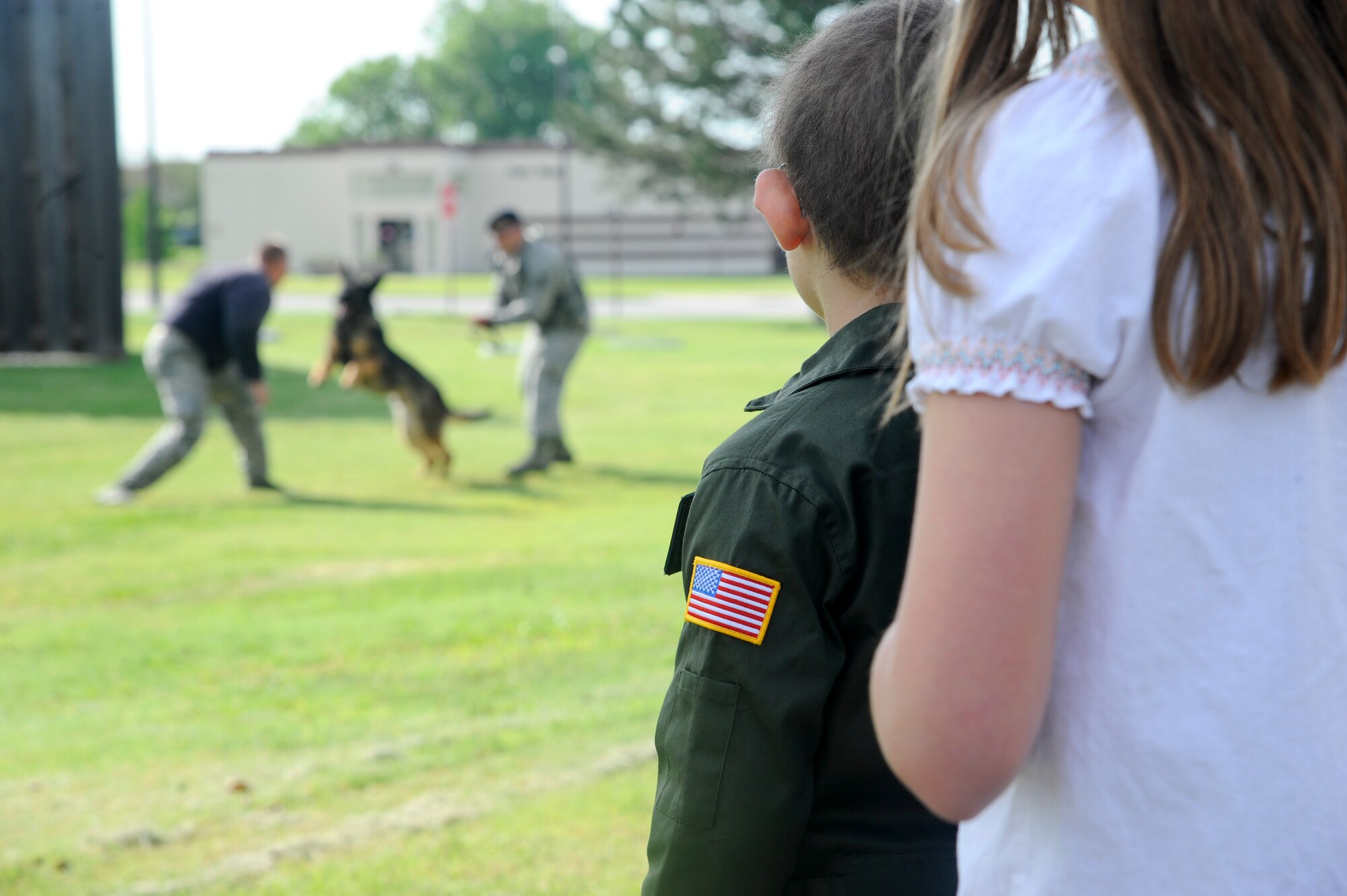 Clair Stewart, who was selected to be a ‘Pilot for a Day,’ observes a military working dog demonstration June 20, 2014, at McConnell Air Force Base, Kan. The program sponsors medically-challenged youth to tour departments throughout the base and experience several activities that are done on a military installation. (U.S. Air Force photo/Airman 1st Class John Linzmeier)