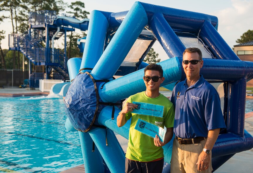 U.S. Air Force Airman 1st Class Reniro Viguilla (left), 23d Aerospace Medicine Squadron dental technician, poses for a photo with Col. Chad Franks, 23d Wing commander, after winning the water wheel challenge at Moody Air Force Base, Ga., June 19, 2014. Not only did Viguilla earn bragging rights after beating his 23d Wing commander’s time, but he also earned the Wing King’s parking spot for two weeks. (U.S. Air Force photo by Senior Airman Douglas Ellis/Released)