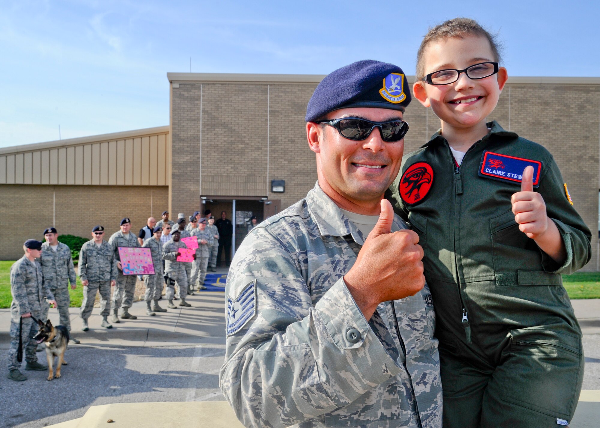 Tech. Sgt. Michael Johns, 22nd Security Forces Squadron resource protection NCOIC, and Claire Stewart pose for a picture, June 20, 2014, at McConnell Air Force Base, Kan. Claire was escorted on base by 22nd SFS vehicles during her experience as ‘Pilot for a Day,’ a program that sponsors medically-challenged youths to experience events and activities throughout various base units, giving them a break from the challenges they face with their ailments. (U.S. Air Force photo/Airman 1st Class John Linzmeier)
