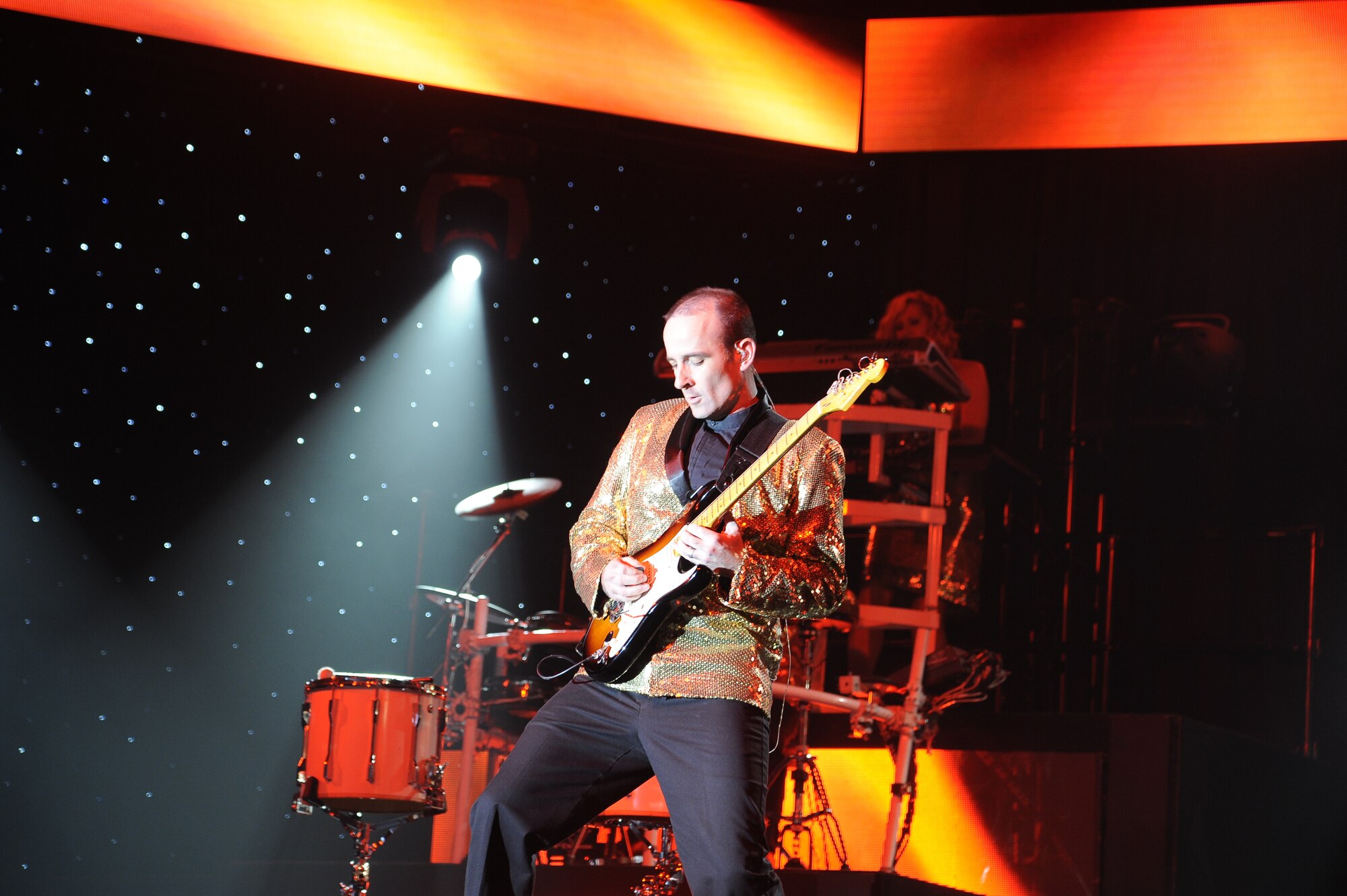 Master Sgt. Justin Worley, Tops In Blue musician, plays lead guitar during the opening act of the Tops In Blue performance at the Montana Expopark in Great Falls on June 23. During the performance, members of the Tops In Blue team performed songs such as “Let It Go” from the movie Frozen, “Suit and Tie” by Jay-Z and Justin Timberlake as well as classic rock and jazz ensembles. (U.S. Air Force photo/Airman 1st Class Collin Schmidt)
