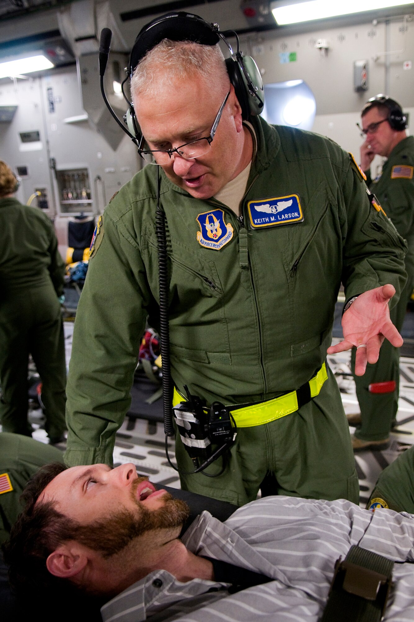 Maj. Keith M. Larson, 445th Aeromedical Evacuation Squadron flight nurse, talks with Rocky Walls, with 12 Stars Media, about his experience as a patient with a simulated collapsed lung during a training flight over Kentucky Aug. 18, 2014. Walls and media representatives from both Indiana and Ohio got a chance to fly with the 434th Air Refueling Wing from Grissom Air Reserve Base, Ind., and the 445th Airlift Wing from Wright-Patterson Air Force Base, Ohio. (U.S. Air Force photo/Tech. Sgt. Mark R. W. Orders-Woempner)