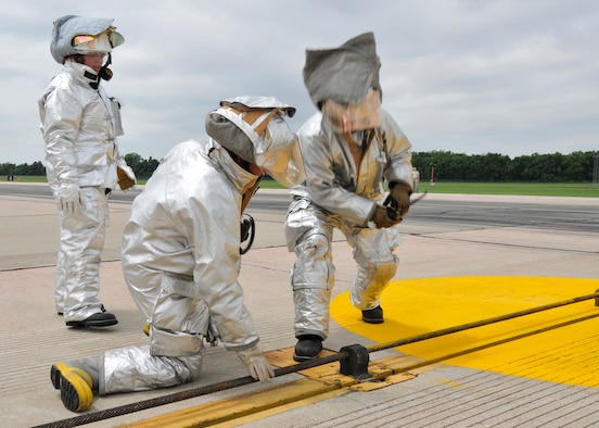 Firefighters with the 114th Civil Engineer Squadron completed annual training on a simulated engagement of the arresting cable on the runway at Joe Foss Field, S.D., June 17, 2014.  A prompt transition from a barrier engagement to its readiness ensures aircraft can continue using the runway and that the 114th Fighter Wing is as efficient and effective as possible.(National Guard photo by Staff Sgt. Luke Olson/Released)