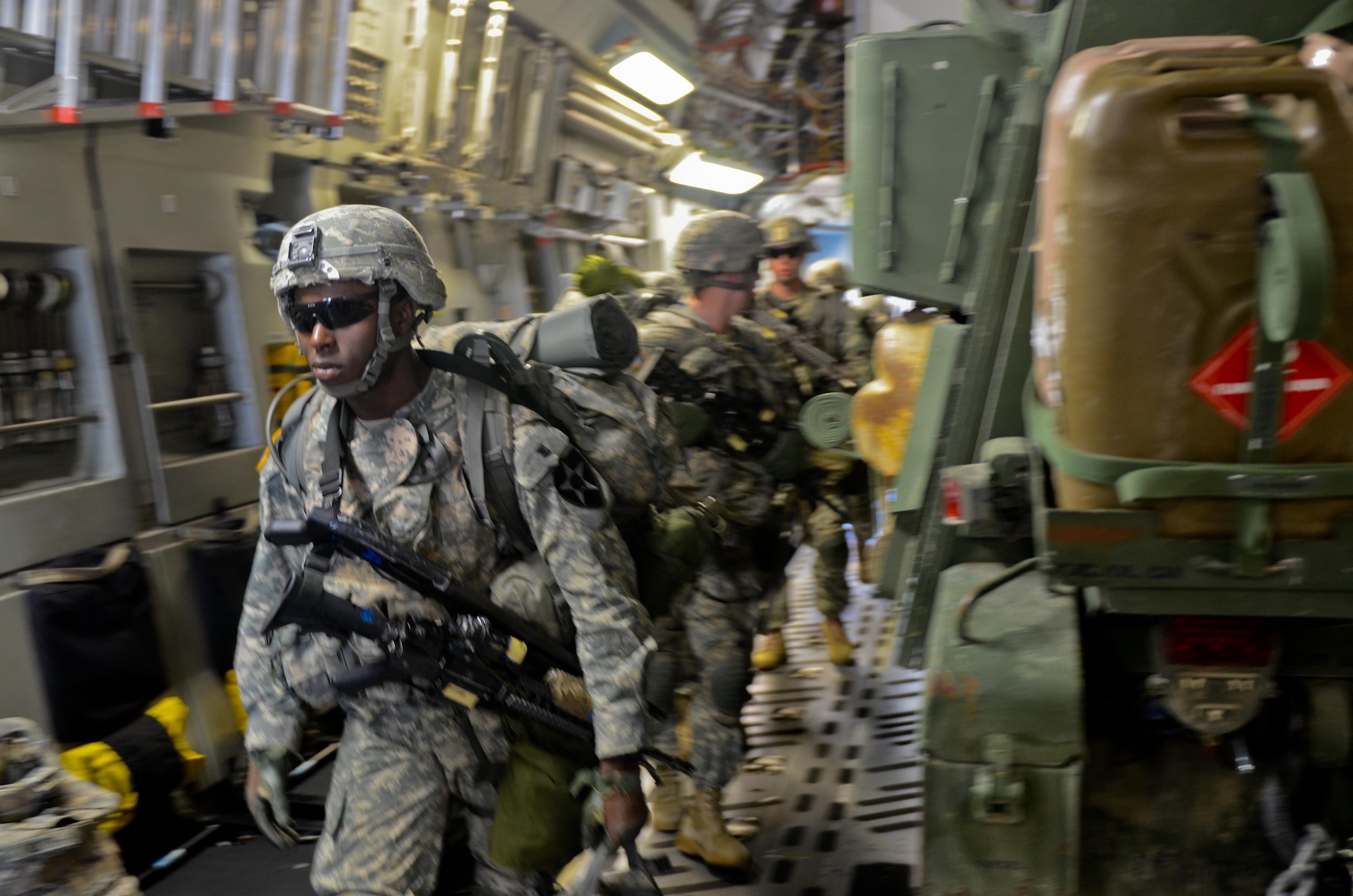 U.S. Army Pvt. Travius Raines, a rifleman with 5th Battalion, 20th Infantry Regiment, 3-2 Stryker Brigade Combat Team, 7th Infantry Division, loads a C-17 Globemaster III with his gear and two Stryker combat vehicles during a training exercise June 19, 2014, at Joint Base Lewis-McChord, Wash. The training allowed Soldiers and Airmen to work together and practice loading and unloading Strykers. (U.S. Army photo/Staff Sgt. Justin Naylor)