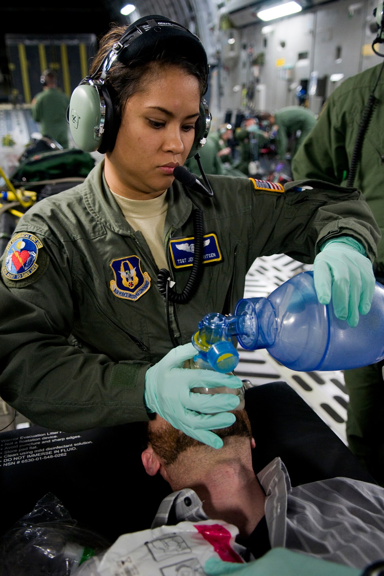 Tech. Sgt. Jennifer Gerritsen, 445th Aeromedical Evacuation Squadron aeromedical evacuation technician, trains on treating Rocky Walls, with 12 Stars Media, who served as a patient with a simulated collapsed lung during a training flight over Kentucky Aug. 18, 2014. Walls and media representatives from both Indiana and Ohio got a chance to fly with the 434th Air Refueling Wing from Grissom Air Reserve Base, Ind., and the 445th Airlift Wing from Wright-Patterson Air Force Base, Ohio. (U.S. Air Force photo/Tech. Sgt. Mark R. W. Orders-Woempner)