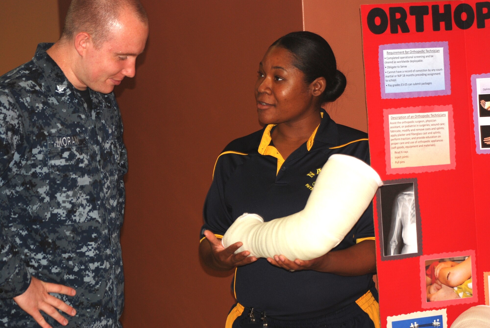 Petty Officer 2nd Class Loveann Burch, Naval Health Clinic Charleston orthopedic technician, shows Petty Officer 3rd Class Michael Moran, NHCC Hospital corpsman, a long-arm cast used to treat orthopedic patients during NHCC's Navy Enlisted Classification fair June 23, 2014, at NHCC on Joint Base Charleston, S.C. The fair showcased the many career fields within the Hospital Corps. Representatives from each NHCC department staffed tables filled with interactive displays and information about the Hospital Corps, Hospital Corps classifications and various programs available to enlisted Sailors. (US Navy photo/Kris Patterson)
