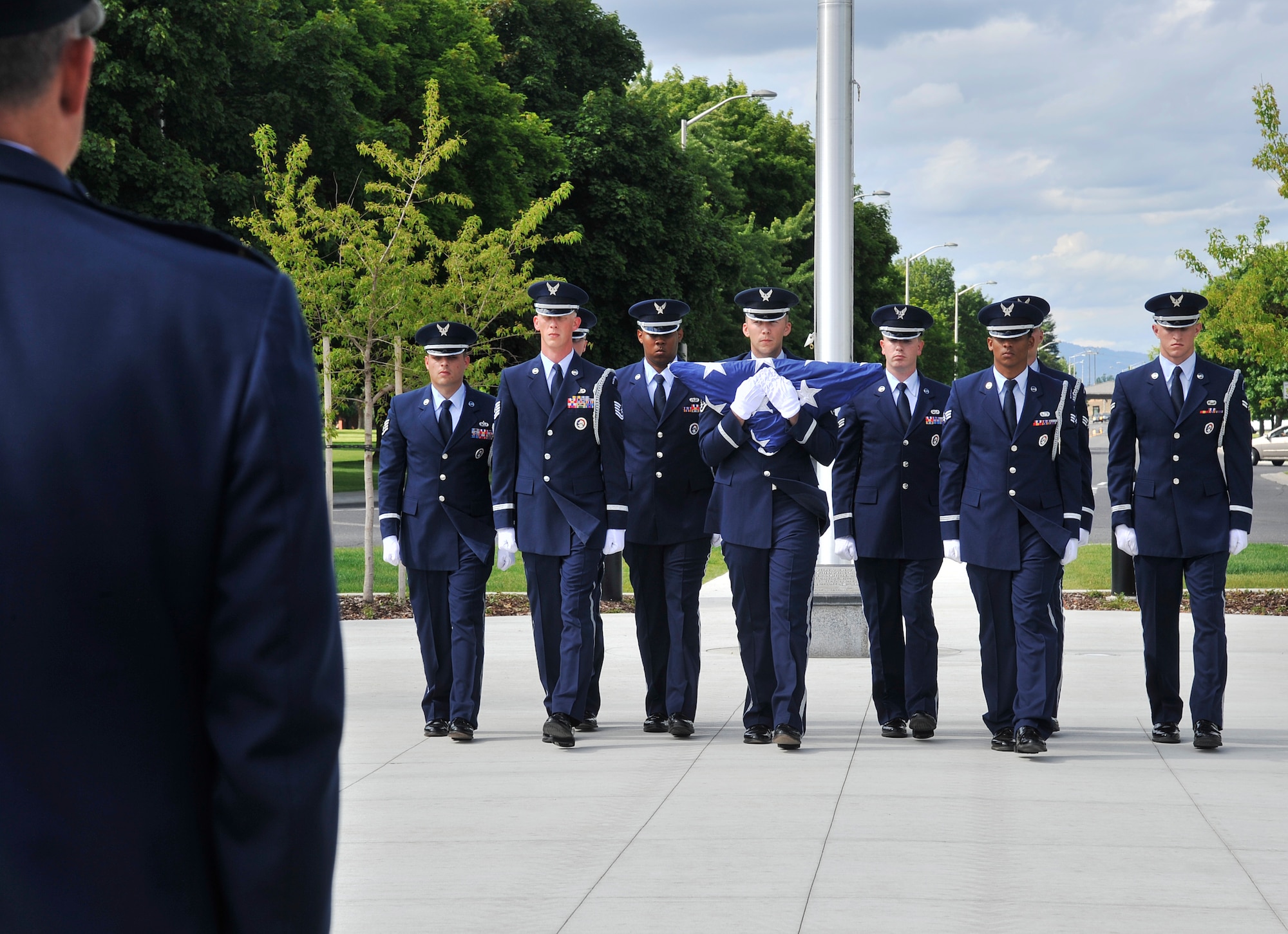 Team Fairchild Honor Guard members begin folding the flag during a retreat ceremony held at Fairchild Air Force Base, Wash., June 24, 2014. The ceremony was held on the 20th anniversary of the the B-52 Stratofortress crash in 1994. The four Airmen who lost their lives include  Lt. Col. Arthur "Bud" Holland, Lt. Col. Mark McGeehan, Col. Robert Wolff, and Lt. Col. Ken Huston. (U.S. Air Force photo by Senior Airman Mary O'Dell/Released)