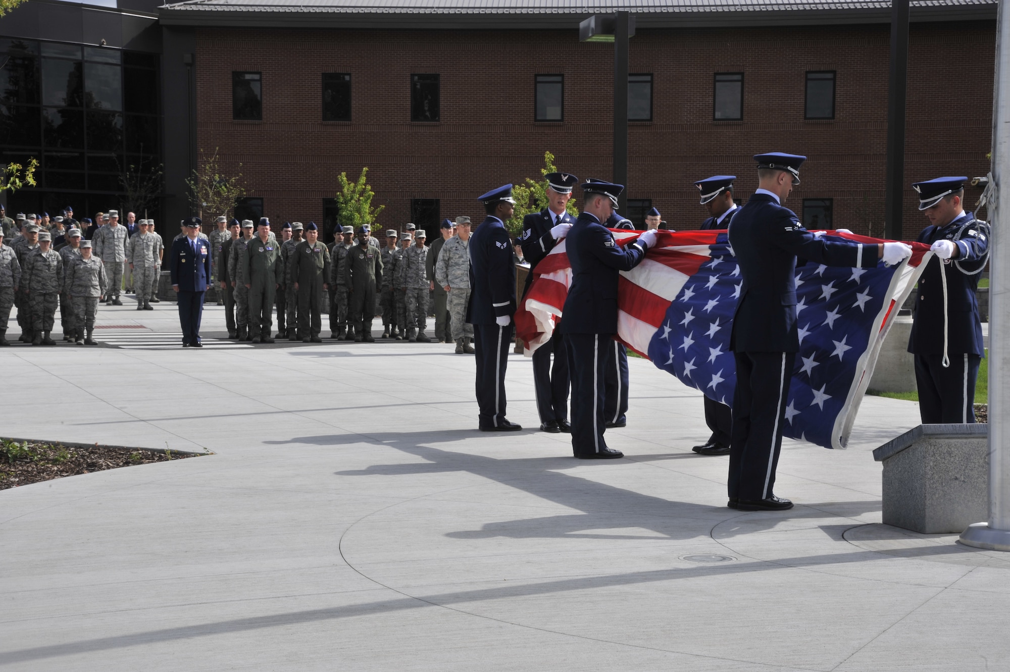 Team Fairchild Honor Guard members begin folding the flag during a retreat ceremony held at Fairchild Air Force Base, Wash., June 24, 2014. The ceremony was held on the 20th anniversary of the the B-52 Stratofortress crash in 1994. The four Airmen who lost their lives include  Lt. Col. Arthur "Bud" Holland, Lt. Col. Mark McGeehan, Col. Robert Wolff, and Lt. Col. Ken Huston. (U.S. Air Force photo by Senior Airman Mary O'Dell/Released)