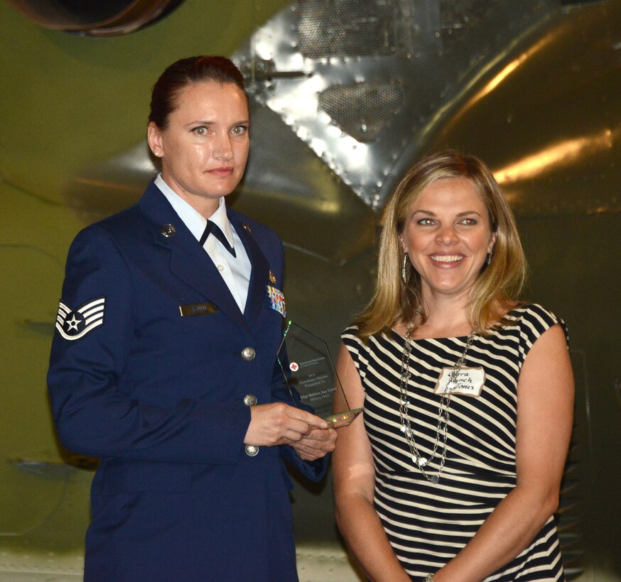 Staff Sgt. Melissa Erwin, left, holds her Hometown Military Hero award during a ceremony June 25, 2014, at the Museum of Aviation, Warner Robins, Georgia. Lorra Lynch Jones, news anchor for WMAZ Channel 13, right, presented the award. (U.S. Air Force photo/Master Sgt. Chance Babin)