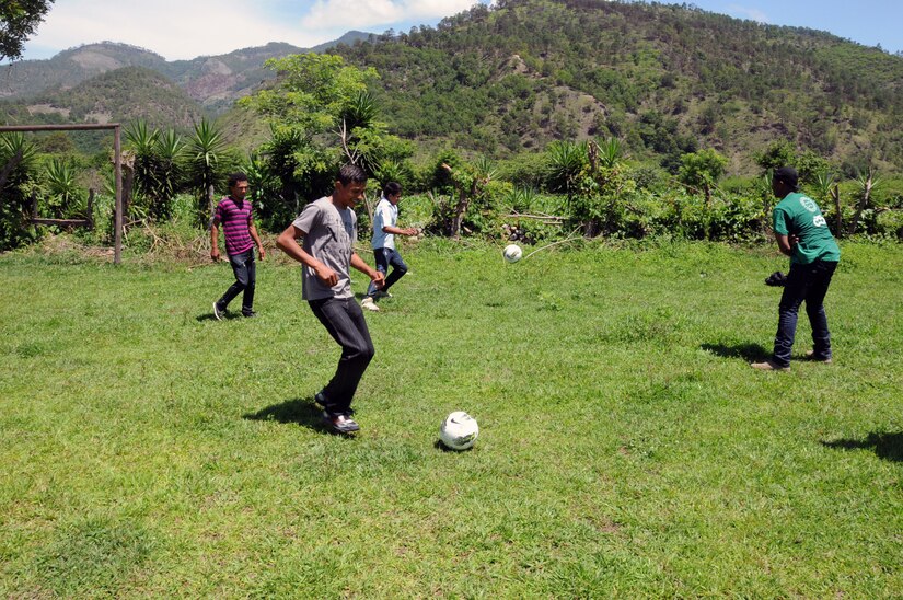 Boys from the village of Proterillos and a Joint Task Force-Bravo member kick around the soccer balls donated by the non-profit organization Kick For Nick.  Nearly 130 members of Joint Task Force-Bravo, with the support of Joint Task Force-Bravo’s Joint Security Forces, completed a volunteer five mile round trip hike to deliver more than 4,000 pounds of food, supplies and clothing to families in need in the mountain village of Proterillos outside La Paz, Honduras, June 21, 2014.  The effort was part of the 55th Joint Task Force-Bravo Chapel Hike, a venerable tradition during which the servicemembers donate money to purchase food and supplies and then carry them on a hike through the mountains to deliver to local, underserviced communities.  (Photo by U. S. Air National Guard Capt. Steven Stubbs)