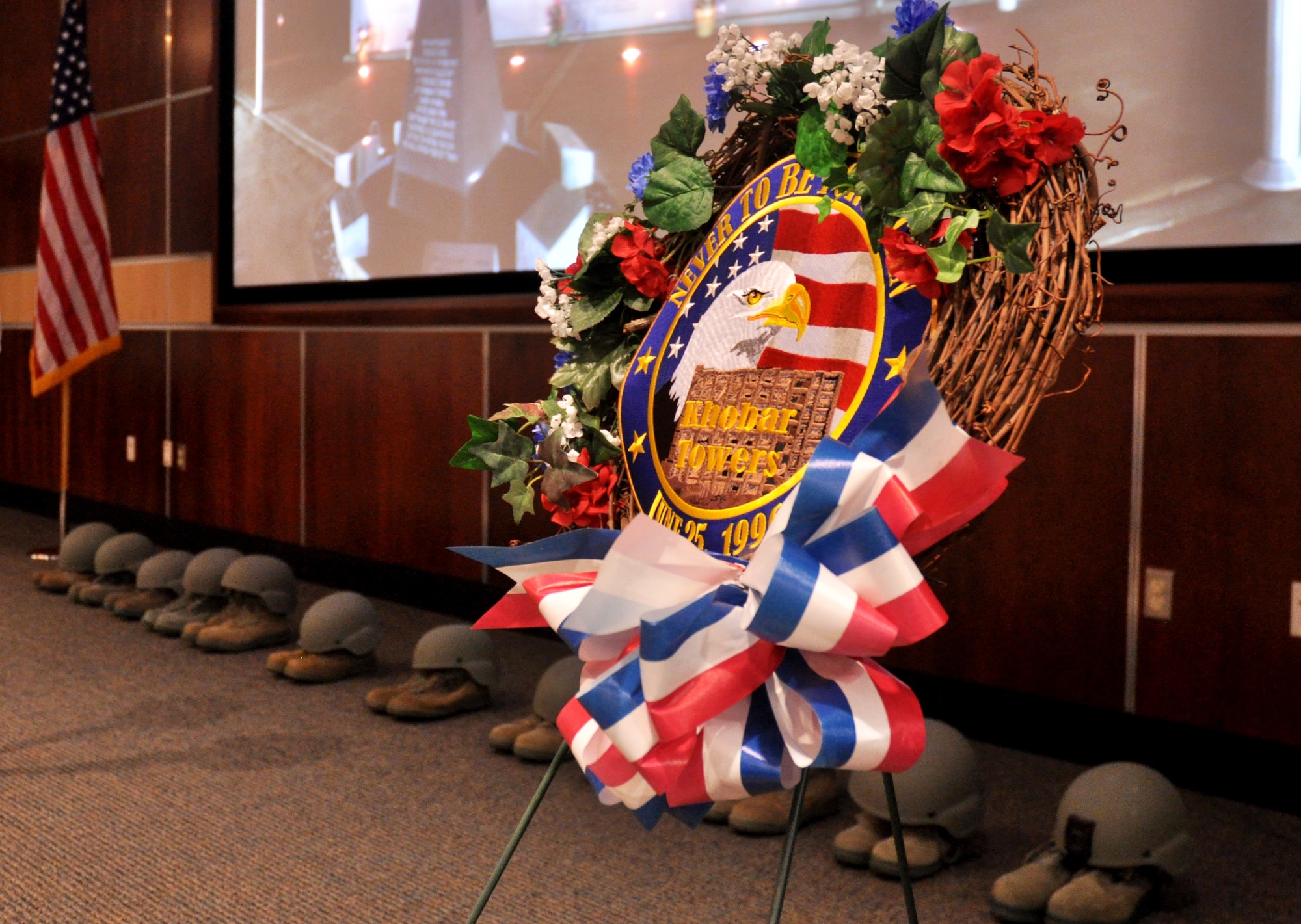 A wreath, helmets and boots were placed at the front of the room to honor the fallen during the Khobar Towers memorial ceremony June 25 at Eglin Air Force Base, Fla. The ceremony marks the 18th anniversary of the tragic bombing that killed 19 service members including 12 33rd Fighter Wing Airmen. Each year a ceremony is held by the Nomads to commemorate their brothers who’ve “ceased their wandering.” Due to inclement weather, the ceremony was moved indoors. (U.S. Air Force photo/Ilka Cole)