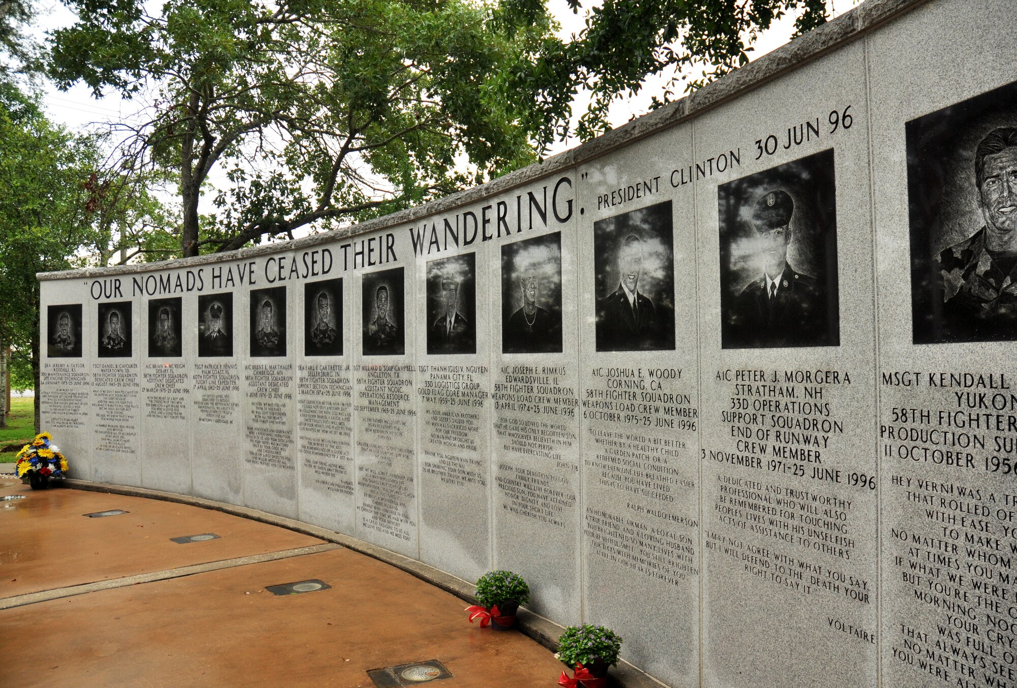 Flowers are placed at the 33rd Fighter Wing's Nomad Memorial on the 18th anniversary of the tragic Khobar Towers bombing in Saudi Arabia June 25. The memorial wall and flaming sword were constructed in 1997 to honor the 12 Nomads killed. Nineteen U.S. servicemembers gave the ultimate sacrifice and 400 casualties were reported.  Annually, the 33rd FW hosts a ceremony to remember their sacrifice.(U.S. Air Force photo/Ilka Cole)
