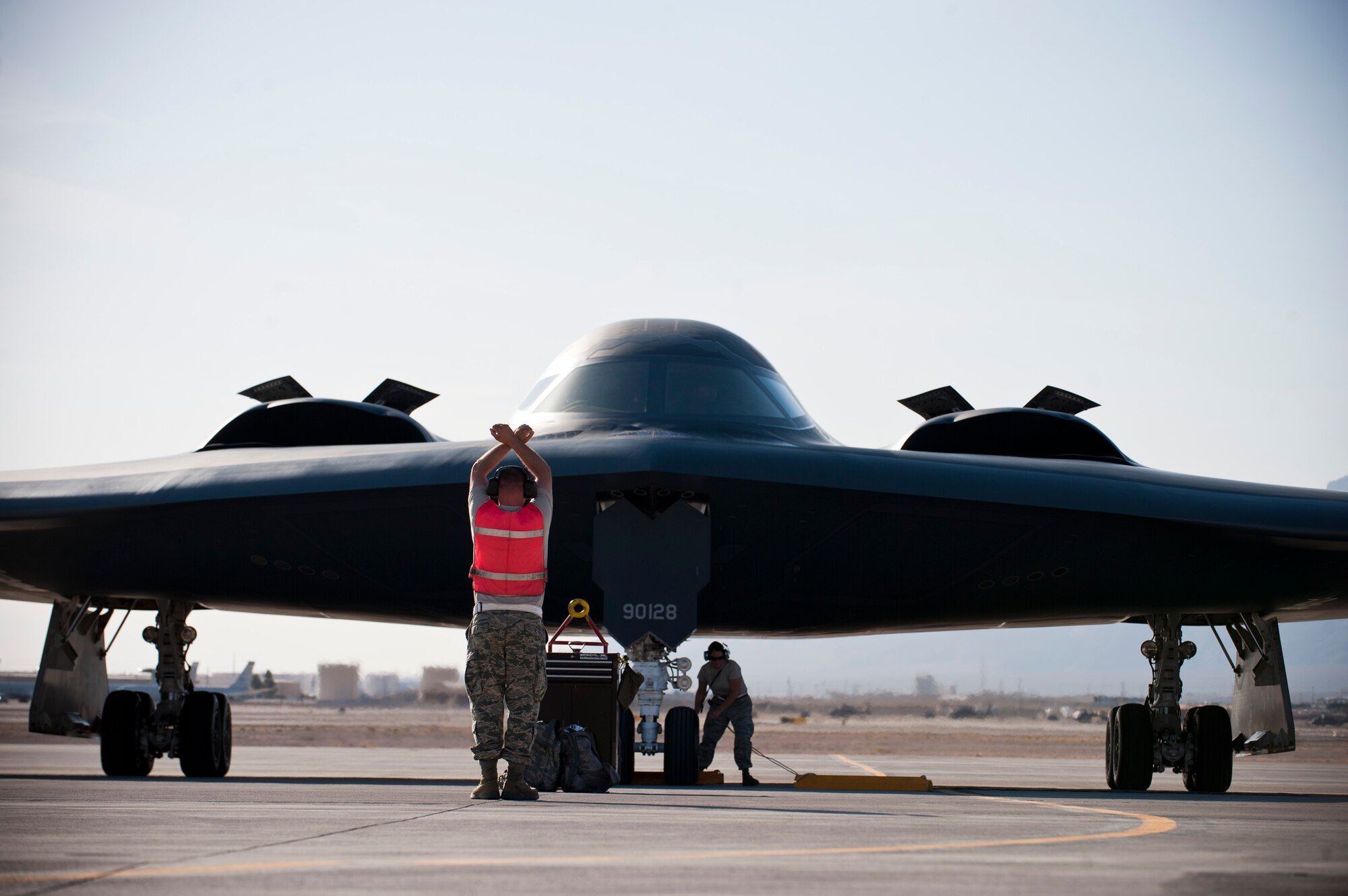 Staff Sgt. Scott Schroer (left), and Tech. Sgt. Ronda Bollinger, crew chiefs assigned to the 131st Bomb Wing, Whiteman Air Force Base, Mo. marshal a B-2 Spirit assigned to the 509th Bomb Wing from Whiteman AFB, June 23, 2014, at Nellis AFB, Nev. The aircraft maintainers from the 131st Bomb Wing are all Air National Guard members. The guard units, along with active duty units, are participating in total force integration with the U.S. Air Force Weapons School. (U.S. Air Force photo by Airman 1st Class Thomas Spangler)