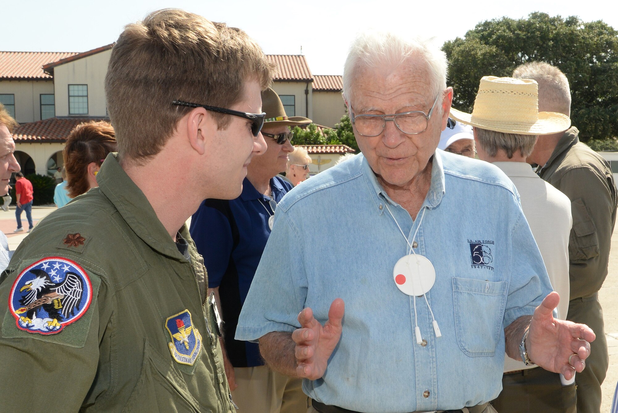 Maj. Aaron Milledge (left), 435th Fighter Training Squadron, listens to Charles Cleveland, a retired Air Force lieutenant general and flying ace, share his flying experiences June 20 while at Joint Base San Antonio-Randolph. Thirteen ace pilots visited Joint Base San Antonio-Randolph June 20. The American Fighter Aces Association was founded in 1960 to recognize the 1,450 combat pilots who received the special distinction of becoming an ace by destroying five or more hostile aircraft in air-to-air combat. (U.S. Air Force photo by Johnny Saldivar)