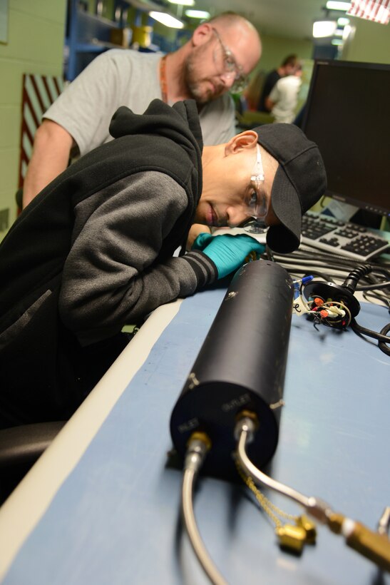 Randy Trotter trains Dung Tran on a purge eater, which pushes cold air in, heats it and then pushes it back out. The instrument mechanics are part of the 550th Commodities Maintenance Squadron’s Oxygen Maintenance Depot. (Air Force photo by Kelly White)