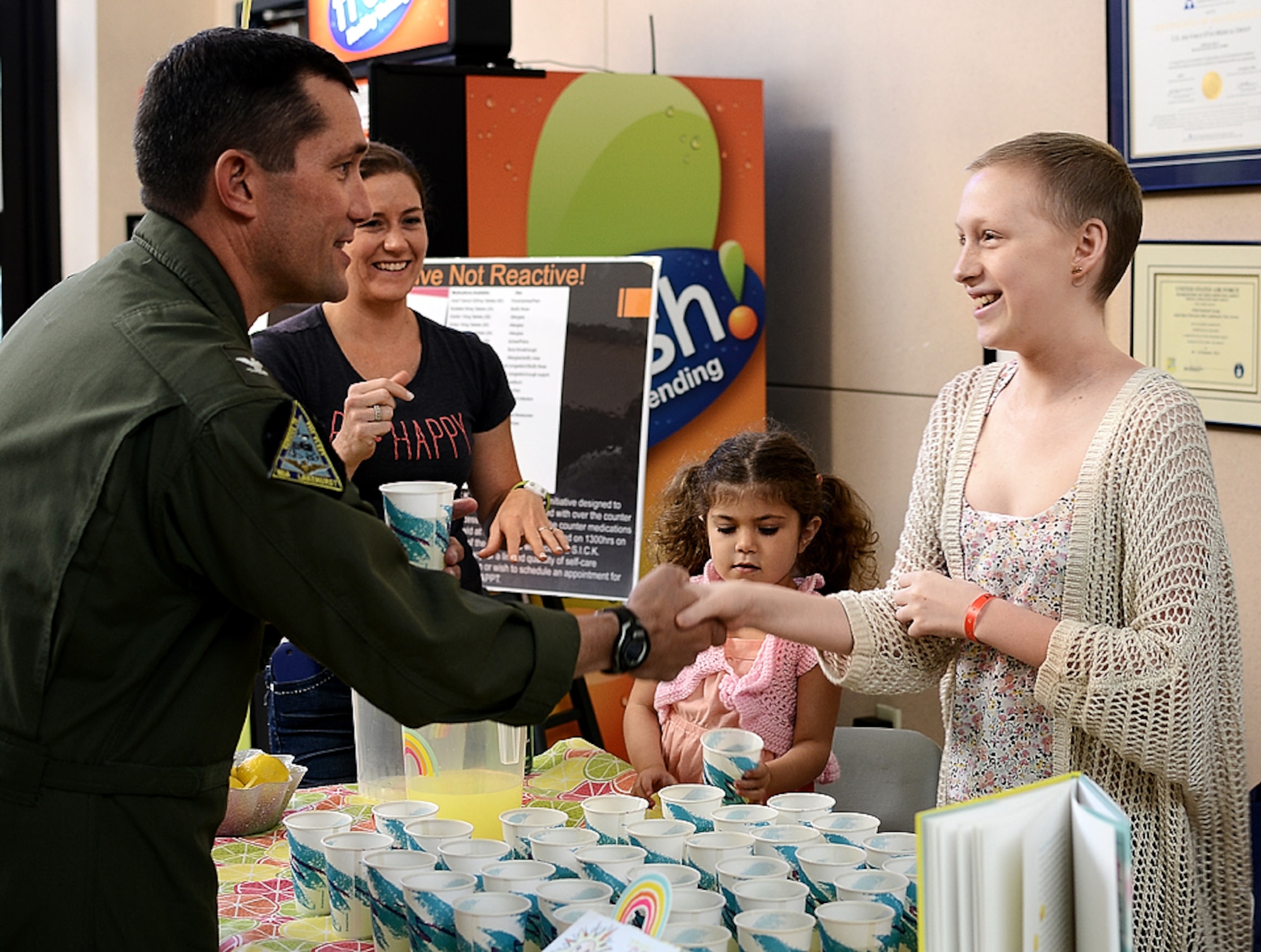 Navy Capt. Christopher Fletcher, Joint Base McGuire-Dix-Lakehurst deputy commander, buys the first cup of lemonade from Kaitlyn Kress during her Alex’s Lemonade Stand fundraiser June 12, 2014. The fundraiser raised more than $6,000 for pediatric cancer research. (U.S. Air Force photo)