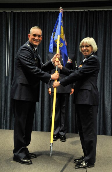 Col. Brian Newberry passes the 92nd Medical Group guidon to Col. Margaret Carey during an assumption of command ceremony at Fairchild Air Force Base, Wash., June 23, 2014. Carey, now 92nd MDG commander, was previously the Chief of the Clinical and Business Analysis Division and enhanced Multi-Service Market Cell Lead at AF Medical Operations Agency, Joint Base San Antonio-Lackland, Texas. She earned a bachelor’s degree in nursing from Thomas Jefferson University, Philadelphia, Pa., in 1985 and in May 1991, was commissioned in the Air Force as a first lieutenant. She is married to Curt Carey and they have two children, Malissa and Justin. Newberry is the 92nd Air Refueling Wing commander. (U.S. Air Force photo by Senior Airman Mary O'Dell/Released)