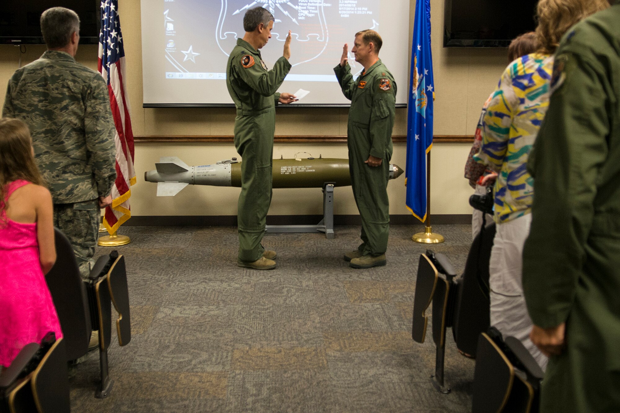 Family, friends and coworkers attend a Pinning On ceremony for Maj. Linden Adams, June 20, 2014, Barksdale Air Force Base, La. Adams was recently promoted to the rank of Major and is read the Oath of Office by Lt. Col. Robert Burgess, 343rd Bomb Squadron commander. (U.S. Air Force photo by Master Sgt. Greg Steele/Released)