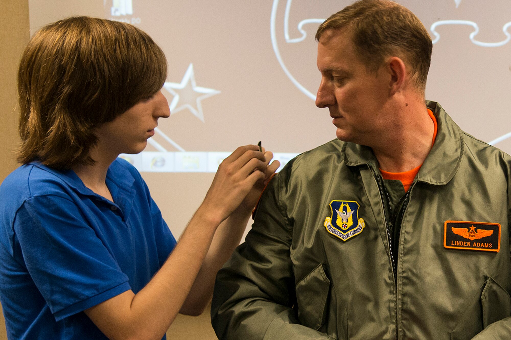 U.S. Air Force Maj. Linden Adams has his rank swapped out by his stepson, Connor Cowan, during a Pinning On ceremony, June 20, 2014, Barksdale Air Force Base, La. Adams is assigned to the 343rd Bomb Squadron and was recently promoted to the rank of Major. (U.S. Air Force photo by Master Sgt. Greg Steele/Released)