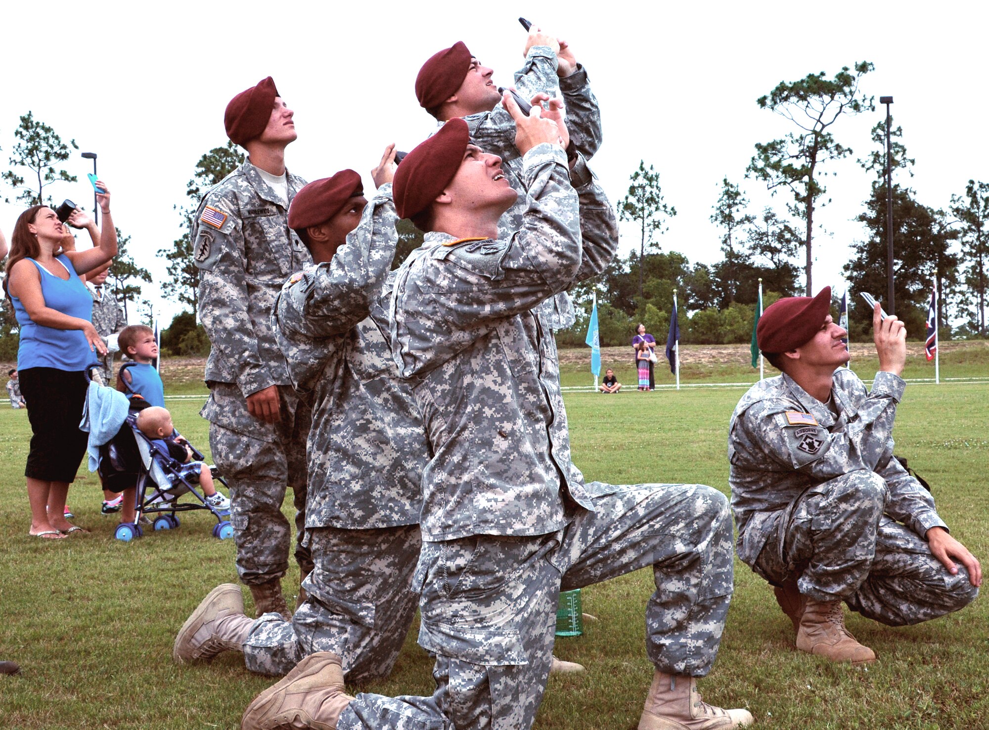 Soldiers from the 7th Special Forces Group (Airborne) ready their cell phones in anticipation of the U.S. Special Operations Command Parachute Team's jump at their headquarters June 24.  The 7th SFG (A) invited members of the Northwest Florida community to their Compound for the Red Empire Community Day.  The day's events featured recognition of the Group's distinguished volunteers and a parachute demonstration by the USSOCOM Para-Commandos.  After the opening ceremony, attendees visited displays manned by Group soldiers to learn more about the 7th SFG (A), its soldiers and its missions. (U.S. Air Force photo/Ilka Cole)
