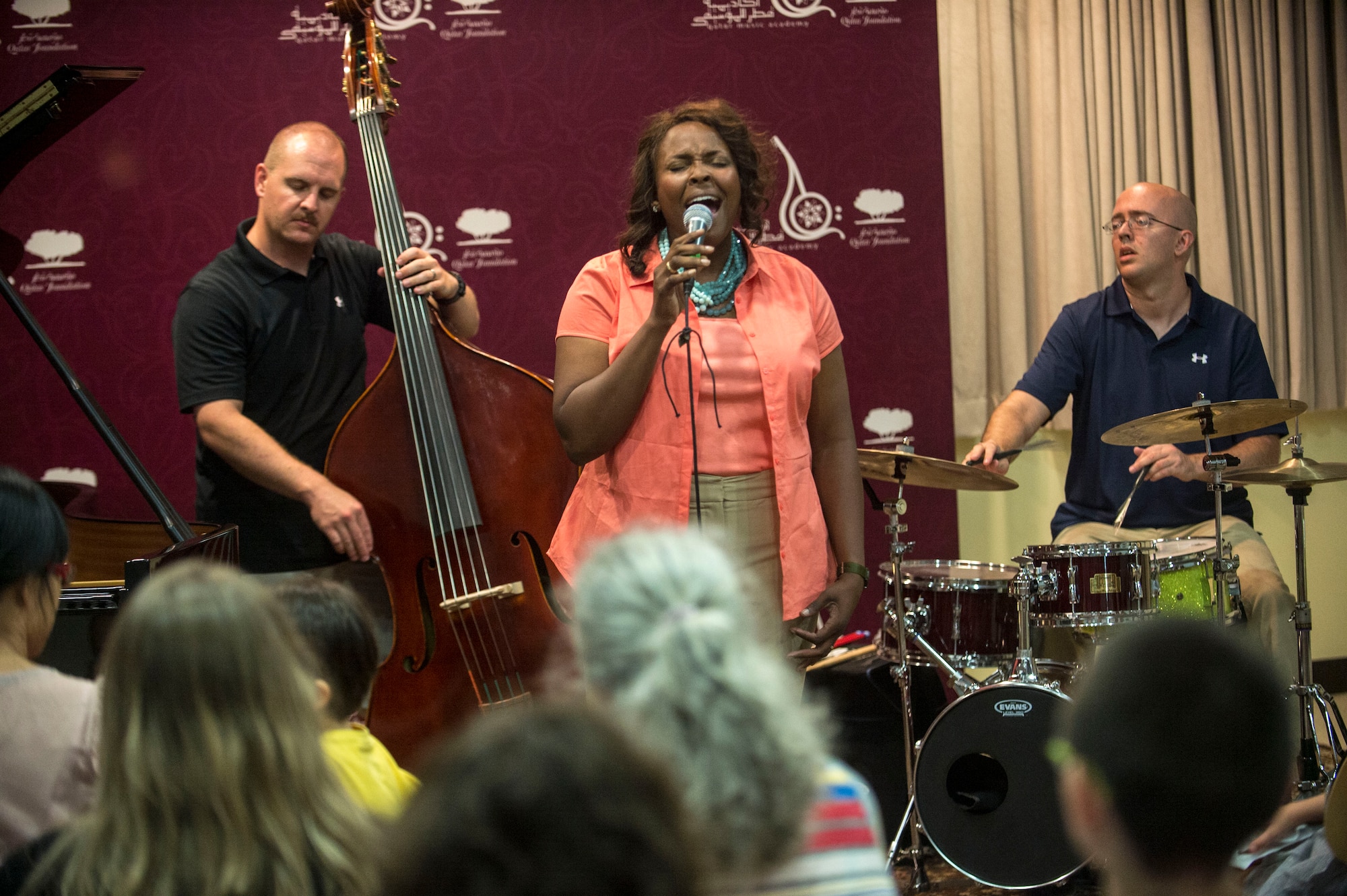 U.S. Air Force Tech. Sgt. Keisha Gwin-Goodin and Senior Airmen Christopher Haughey and Jon-Marc Dale, all assigned to the AFCENT Band at Al Udeid Air Base, Qatar, sing during a workshop with students at the Qatar Music Academy in Doha. Due to Al Udeid Air Base in Qatar recently losing its status as an undisclosed location, members of the U.S. Air Force are now able to conduct community outreach programs such as this. (U.S. Air Force photo by Senior Airman Matthew Bruch) 