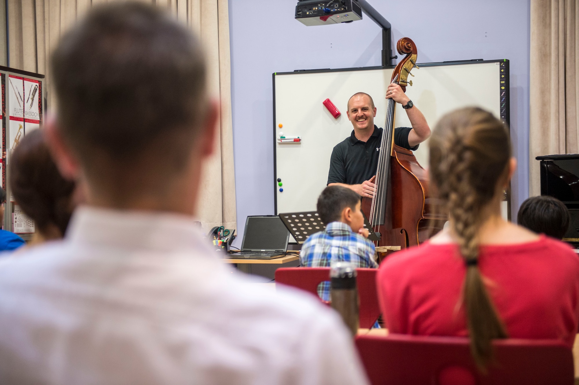 U.S. Air Force Senior Airman Christopher Haughey, a bass player with the AFCENT Band assigned to Al Udeid Air Base, Qatar, conducts a bass workshop with students at the Qatar Music Academy in Doha. Airmen musicians shared experiences and expertise through jazz, brass, percussion and string bass clinics. (U.S. Air Force photo by Senior Airman Matthew Bruch)