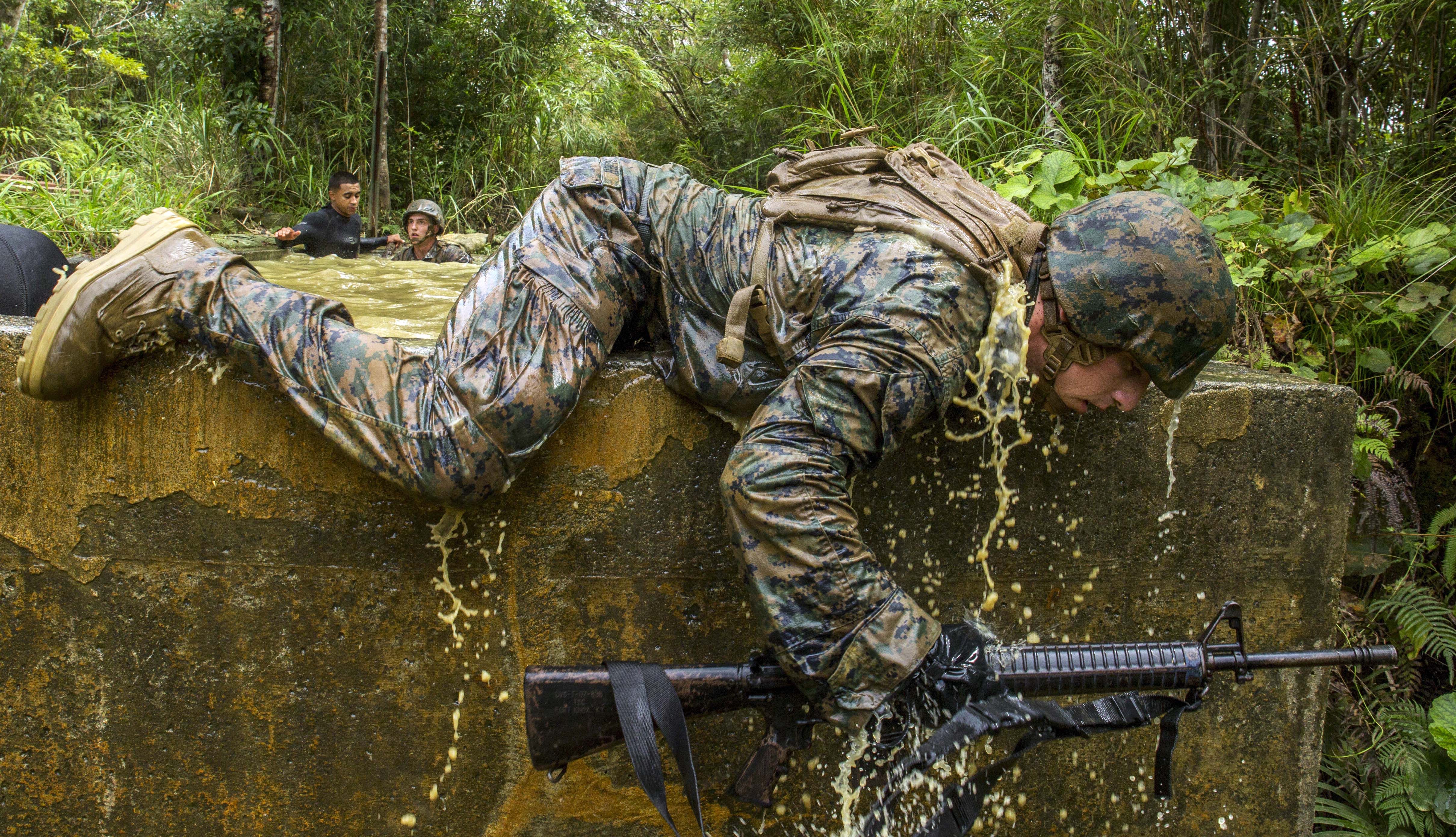 U S Marine Corps Cpl Kevin E Kusler Crawls Over A Stone Wall During u-s-marine-corps-cpl-kevin-e-kusler-crawls-over-a-stone-wall-during