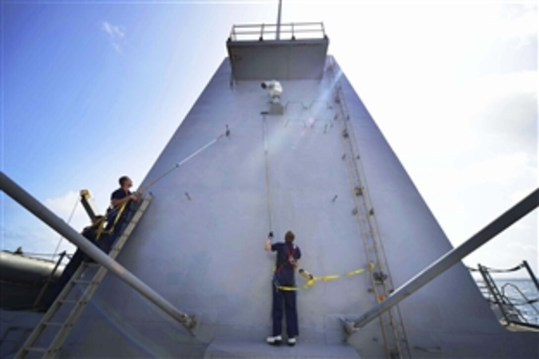 U.S. Navy Petty Officers 2nd Class Christopher Sparks, left, and Adam Deolp add a coat of paint to the USS Nitze in the Indian Ocean, June 21, 2014. The Nitze is conducting operations in the U.S. 6th Fleet area of responsibility. 