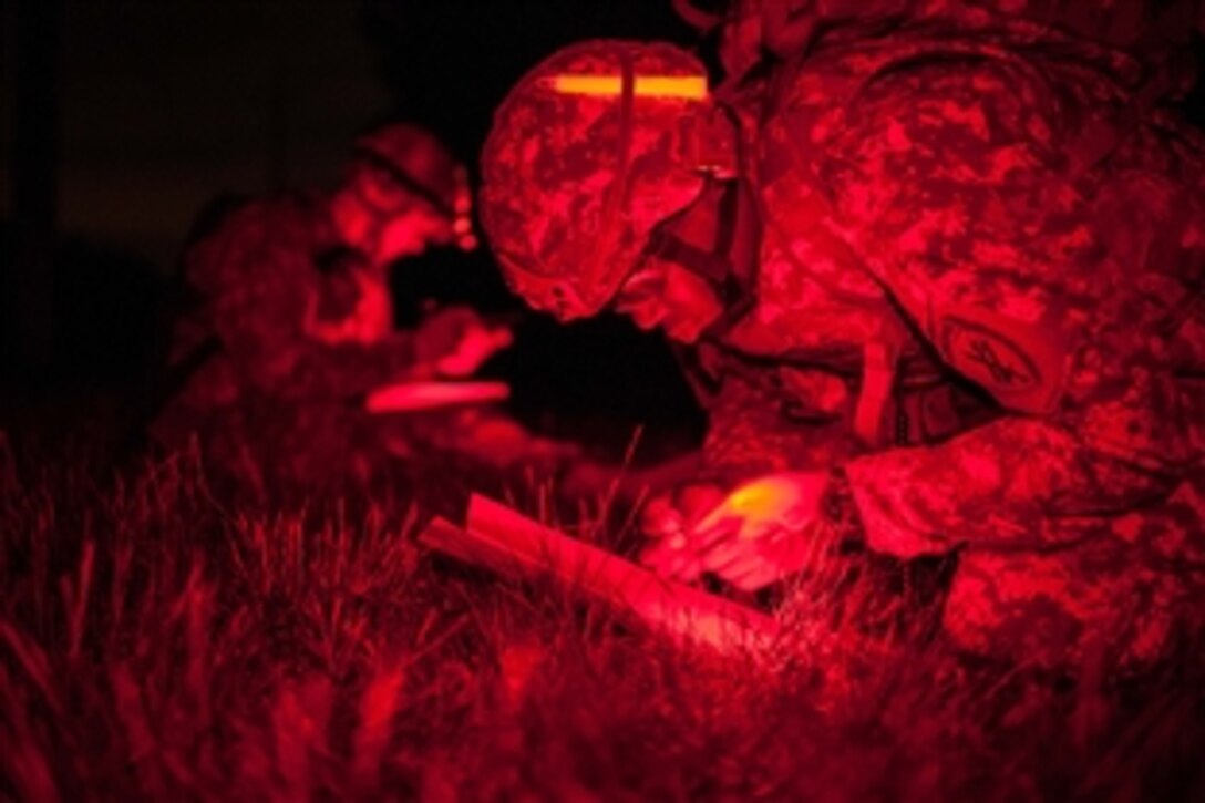 As seen through a night-vision device Army Staff Sgt. Kristopher Stallard checks navigations during the Night Land Navigation event at the 2014 U.S. Army Reserve Best Warrior Competition on Joint Base McGuire-Dix-Lakehurst, N.J., June 24, 2014. The warriors were dropped off and had four hours to plot and find their map points in complete darkness. Stallard is a healthcare specialist assigned to the U.S. Army Civil Affairs and Psychological Operations Command.