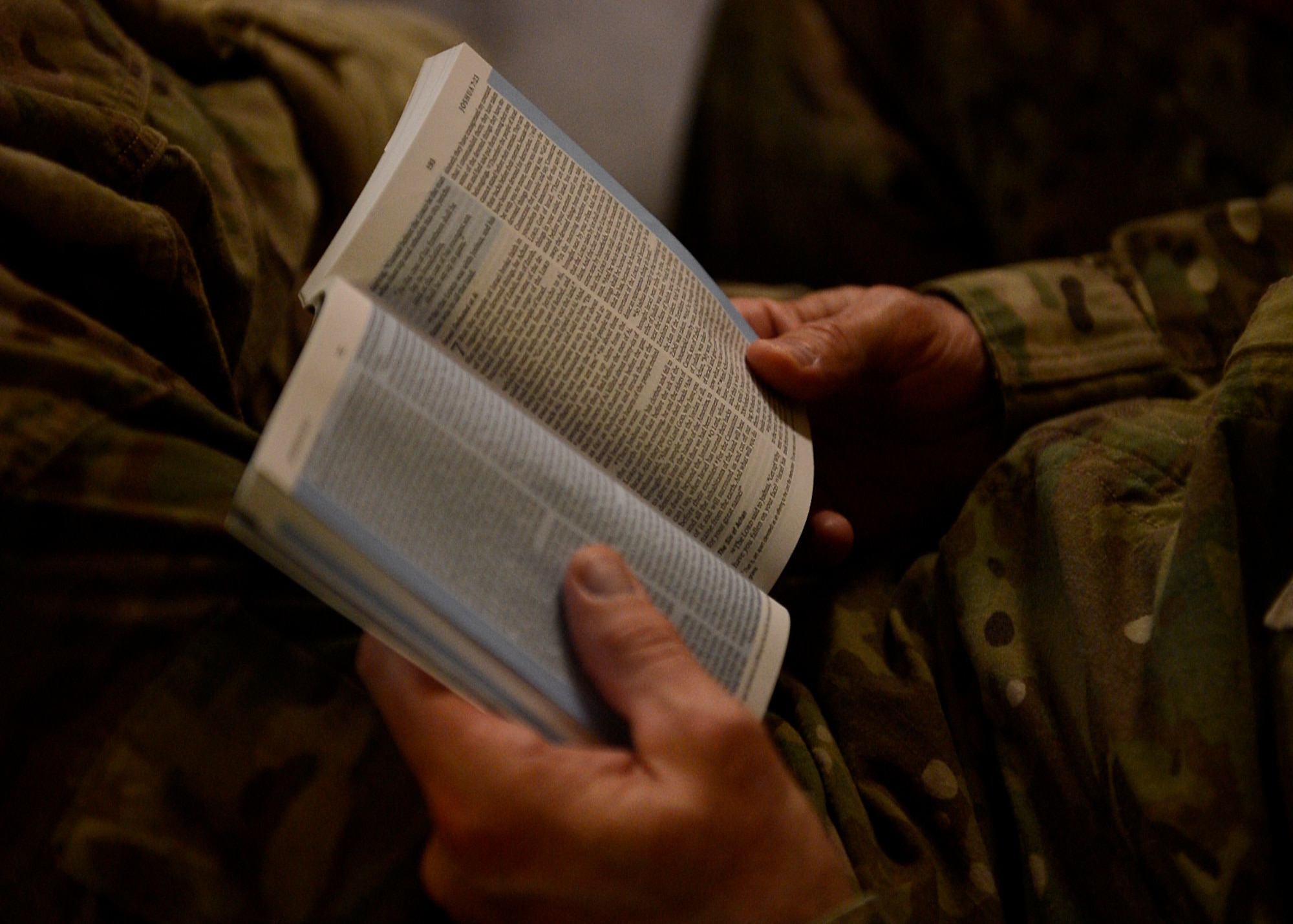 A U.S. Air Force Airman looks at his bible during a service at Bagram Airfield, Afghanistan June 22, 2014.  The Chaplain’s priorities here are to enhance Airmen’s readiness by preparing them with spiritual resiliency, engaging them through ministry of presence and spiritual care and ensuring worship and religious education opportunities are available to all. (U.S. Air Force photo by Staff Sgt. Evelyn Chavez/Released)
