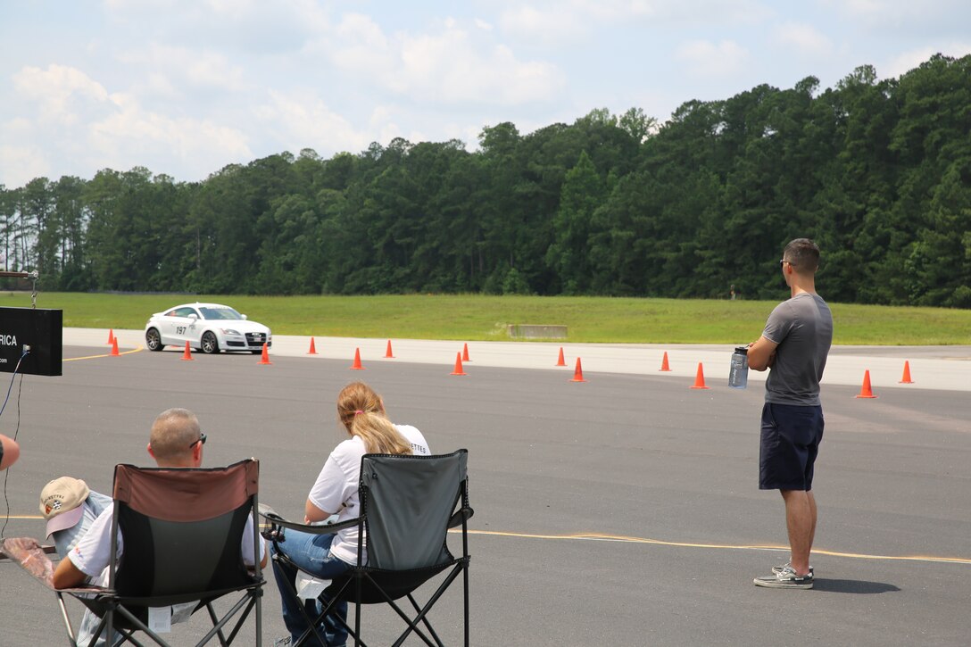 Spectators watch a car pass a timing clock during the Sports Car Club of America autocross event held at foxtrot runway aboard Marine Corps Air Station Cherry Point, N.C., June 21. Marines and SCCA members brought cars of all types and styles, and pushed them to their limits as drivers competed for the fastest times during time trial of the course. 