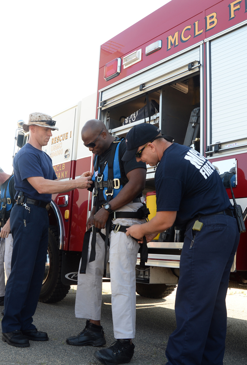 Cpl. Rhamaro Murphy, a member of the Special Reaction Team, Marine Corps Police Department, (center) receives assistance from Marine Corps Logistics Base Albany Fire Department personnel while putting on gear in preparation to rappel from a tower on base, June 6.