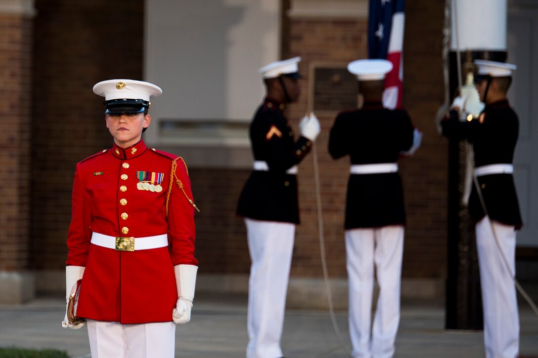 Staff Sgt. Cody Williams, U.S. Marine Drum & Bugle Corps bugler, performs as the U.S. Marine Corps Color Guard finishes evening colors during a concert at Marine Barracks Washington, D.C., June 25, 2014. The concert was to honor the 80th anniversary of the Drum & Bugle Corps. (Official Marine Corps photo by Cpl. Dan Hosack/Released)