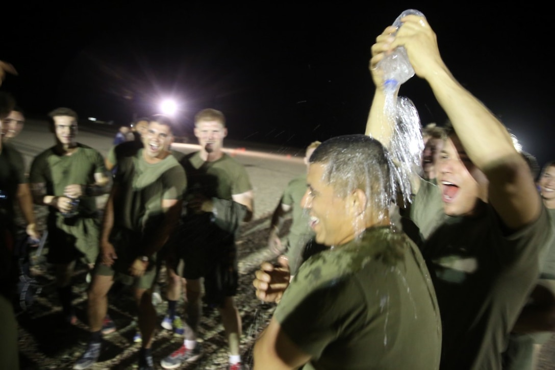 Corporal Leon Mendizabal, right, fire team leader, "Suicide" Charley Company, 1st Battalion, 7th Marine Regiment, pours water on Sgt. Eduardo Ayala, the team captain, after their first victory in the Dwyer World Cup aboard Camp Dwyer, Helmand province, Afghanistan, June 21, 2014. Ayala, a native of Richmond, California, scored the only goal of the game and secured the team's victory. A total of four teams participated in the tournament to include Team America, Afghanistan, Jordan and the World Team (consisting of contractors on the camp). The Marines ultimately defeated the World Team during the final game and were the champions of the tournament.  (U.S. Marine Corps photo by Cpl. Joseph Scanlan / released)