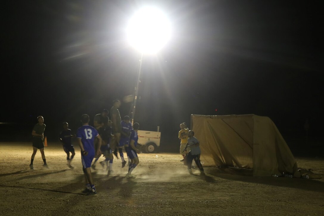 A Marine with "Suicide" Charley Company, 1st Battalion, 7th Marine Regiment, attempts to head the ball into the goal during the championship game in the Dwyer World Cup aboard Camp Dwyer, Helmand province, Afghanistan, June 22, 2014. A total of four teams participated in the tournament to include Team America, Afghanistan, Jordan and the World Team (consisting of contractors on the camp). The Marines ultimately defeated the World Team during the final game and were the champions of the tournament. (U.S. Marine Corps photo by Cpl. Joseph Scanlan / released)