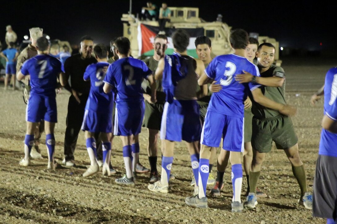 Marines with "Suicide" Charley Company, 1st Battalion, 7th Marine Regiment, shake hands with their opponents after winning the championship game in the Dwyer World Cup aboard Camp Dwyer, Helmand province, Afghanistan, June 22, 2014. A total of four teams participated in the tournament to include Team America, Afghanistan, Jordan and the World Team (consisting of contractors on the camp). The Marines ultimately defeated the World Team during the final game and were the champions of the tournament. (U.S. Marine Corps photo by Cpl. Joseph Scanlan / released)