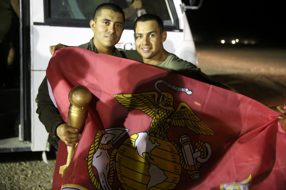 Sergeant Eduardo Ayala, left, field mess chief, "Suicide" Charley Company, 1st Battalion, 7th Marine Regiment, and Sgt. Abidail Estrada, squad leader, pose for a photo with the trophy of the Dwyer World Cup tournament after winning the championship game aboard Camp Dwyer, Helmand province, Afghanistan, June 22, 2014. A total of four teams participated in the tournament to include Team America, Afghanistan, Jordan and the World Team (consisting of contractors on the camp). The Marines ultimately defeated the World Team during the final game and were the champions of the tournament. (U.S. Marine Corps photo by Cpl. Joseph Scanlan / released)