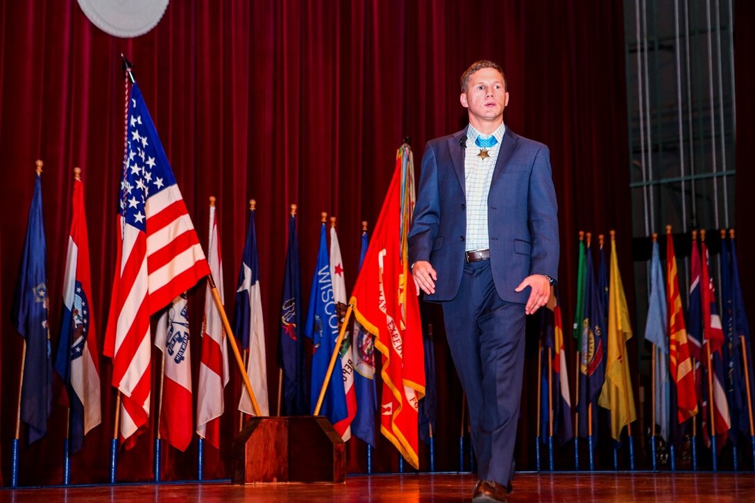 Medal of Honor recipient Cpl. William “Kyle” Carpenter addresses Marines at the base theater aboard Marine Corps Base Camp Pendleton, Calif., June 23, 2014.  During the visit, Carpenter also visited Wounded Warrior Battalion West. Carpenter earned the nation’s highest military award for his actions in Helmand province, Afghanistan, in November 2010. He saved another Marine’s life by shielding him from a grenade blast during an enemy attack.