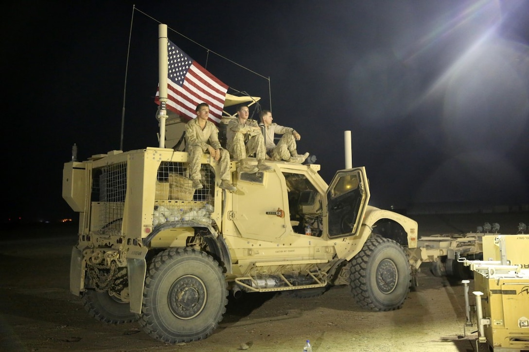 Marines with "Suicide" Charley Company, 1st Battalion, 7th Marine Regiment, watch their fellow Marines play in the Dwyer World Cup from a Mine-Resistant Ambush-Protected All-Terrain Vehicle aboard Camp Dwyer, Helmand province, Afghanistan, June 21, 2014. A total of four teams participated in the tournament to include Team America, Afghanistan, Jordan and the World Team (consisting of contractors on the camp). The Marines ultimately defeated the World Team during the final game and were the champions of the tournament. (U.S. Marine Corps photo by Cpl. Joseph Scanlan / released)