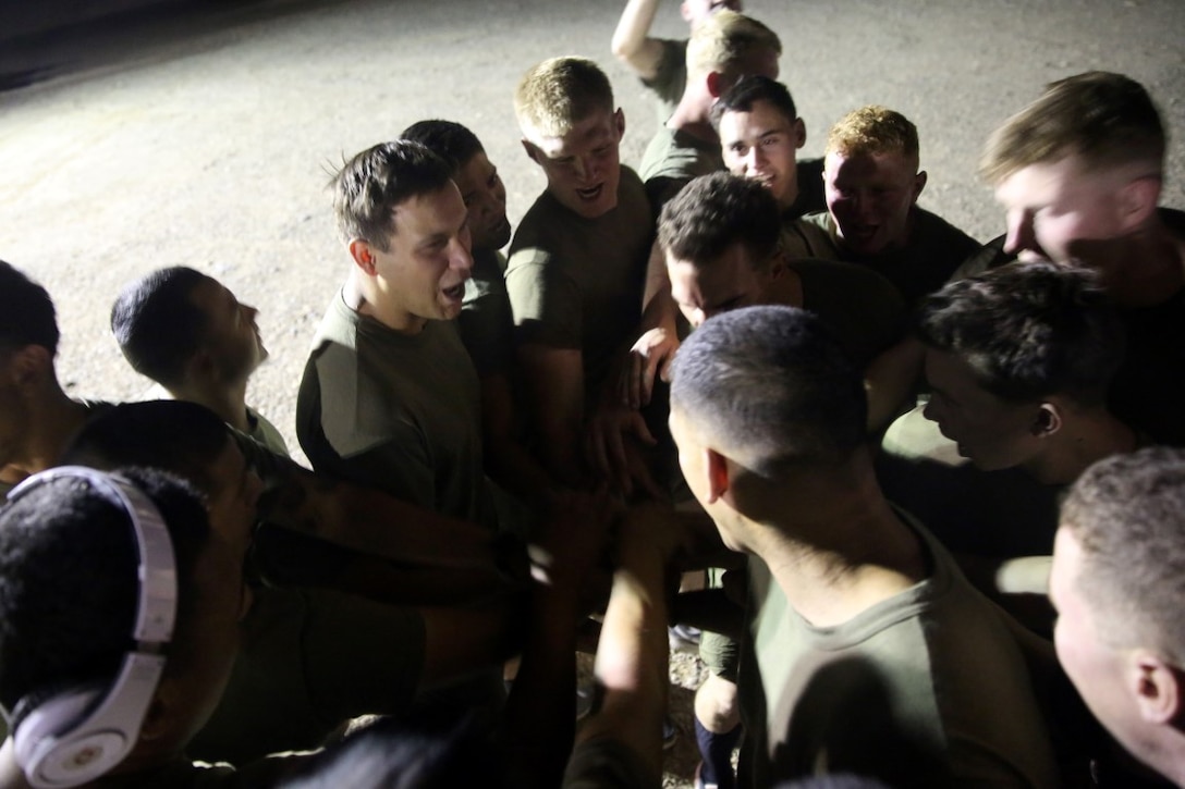 Marines with "Suicide" Charley Company, 1st Battalion, 7th Marine Regiment, gather in a huddle before their first game in the Dwyer World Cup aboard Camp Dwyer, Helmand province,  Afghanistan, June 21, 2014. A total of four teams participated in the tournament to include Team America, Afghanistan, Jordan and the World Team (consisting of contractors on the camp). The Marines ultimately defeated the World Team during the final game and were the champions of the tournament. (U.S. Marine Corps photo by Cpl. Joseph Scanlan / released)