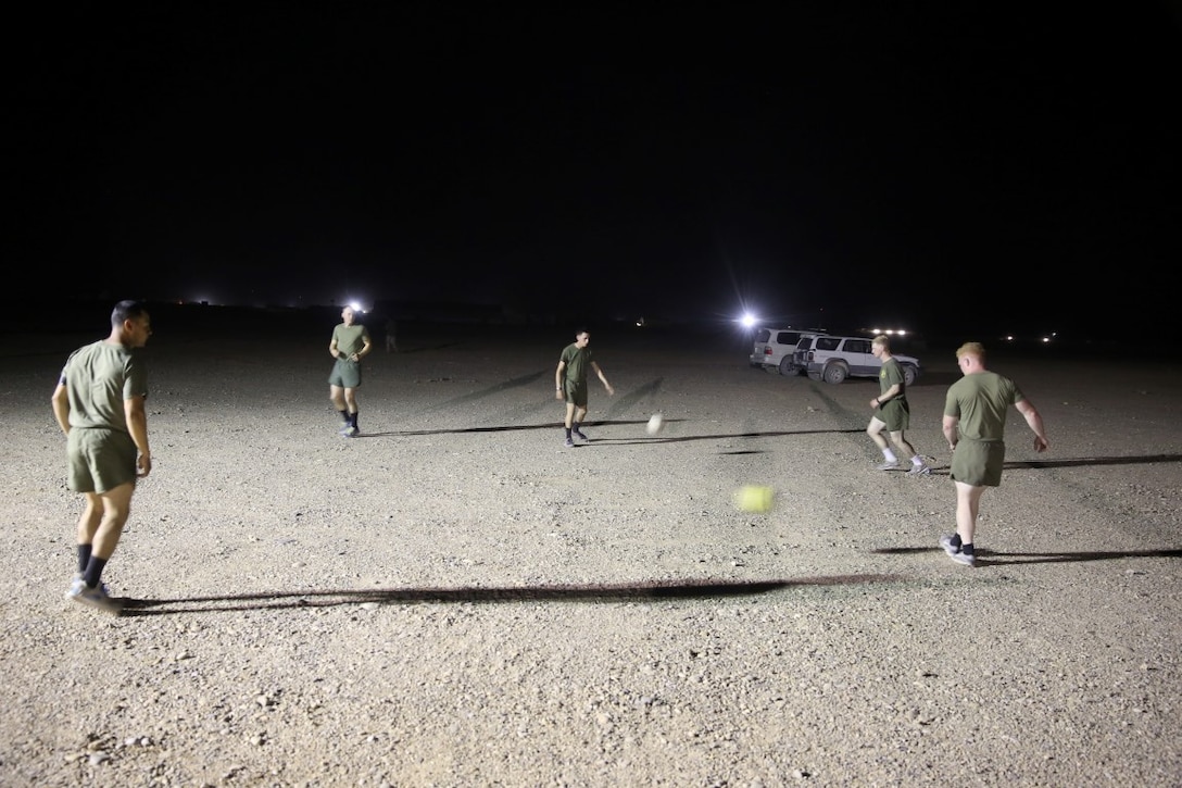 Marines with "Suicide" Charley Company, 1st Battalion, 7th Marine Regiment, conduct passing drills prior to their first match in the Dwyer World Cup aboard Camp Dwyer, Helmand province, Afghanistan, June 21, 2014. A total of four teams participated in the tournament to include Team America, Afghanistan, Jordan and the World Team (consisting of contractors on the camp). The Marines ultimately defeated the World Team during the final game and were the champions of the tournament. (U.S. Marine Corps photo by Cpl. Joseph Scanlan / released)