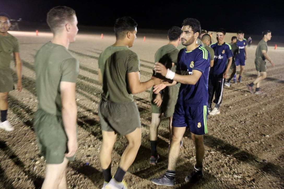 Marines with "Suicide" Charley Company, 1st Battalion, 7th Marine Regiment, shake hands with players from Team Afghanistan after defeating them during the Dwyer World Cup aboard Camp Dwyer, Helmand province, Afghanistan, June 21, 2014. A total of four teams participated in the tournament to include Team America, Afghanistan, Jordan and the World Team (consisting of contractors on the camp). The Marines ultimately defeated the World Team during the final game and were the champions of the tournament. (U.S. Marine Corps photo by Cpl. Joseph Scanlan / released)