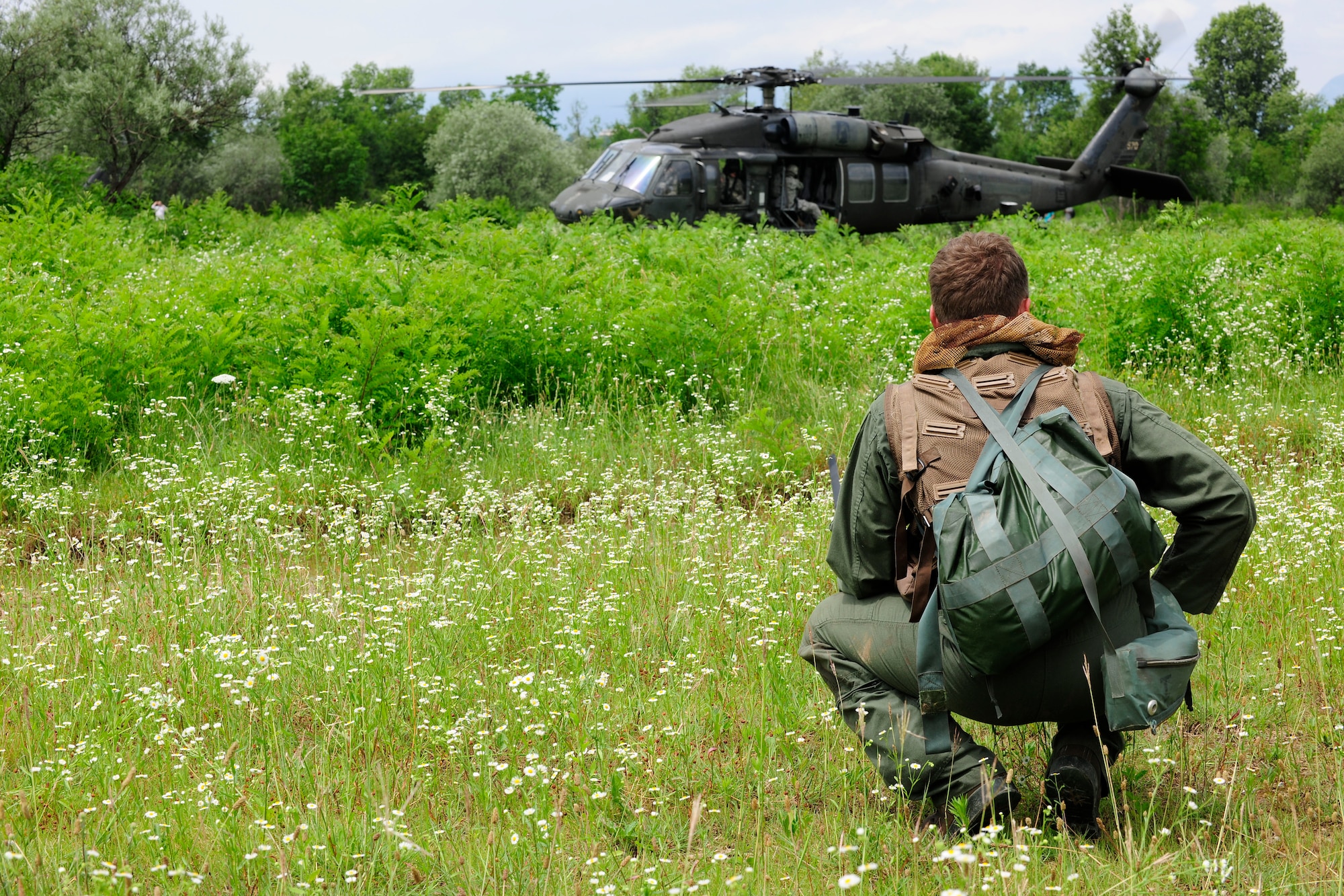 Capt. William Flynt  waits for a UH-60 Black Hawk helicopter during a combat search and rescue training mission, June 24, 2014, at Cellina Meduna training ground near Maniago, Italy. Pilots are taught necessary survival skills to evade capture and get recovered successfully to include: movement, camouflage and signaling techniques. Flynt is a F-16 Fighting Falcon pilot with the 555th Fighter Squadron. (U.S. Air Force photo/Airman 1st Class Ryan Conroy)