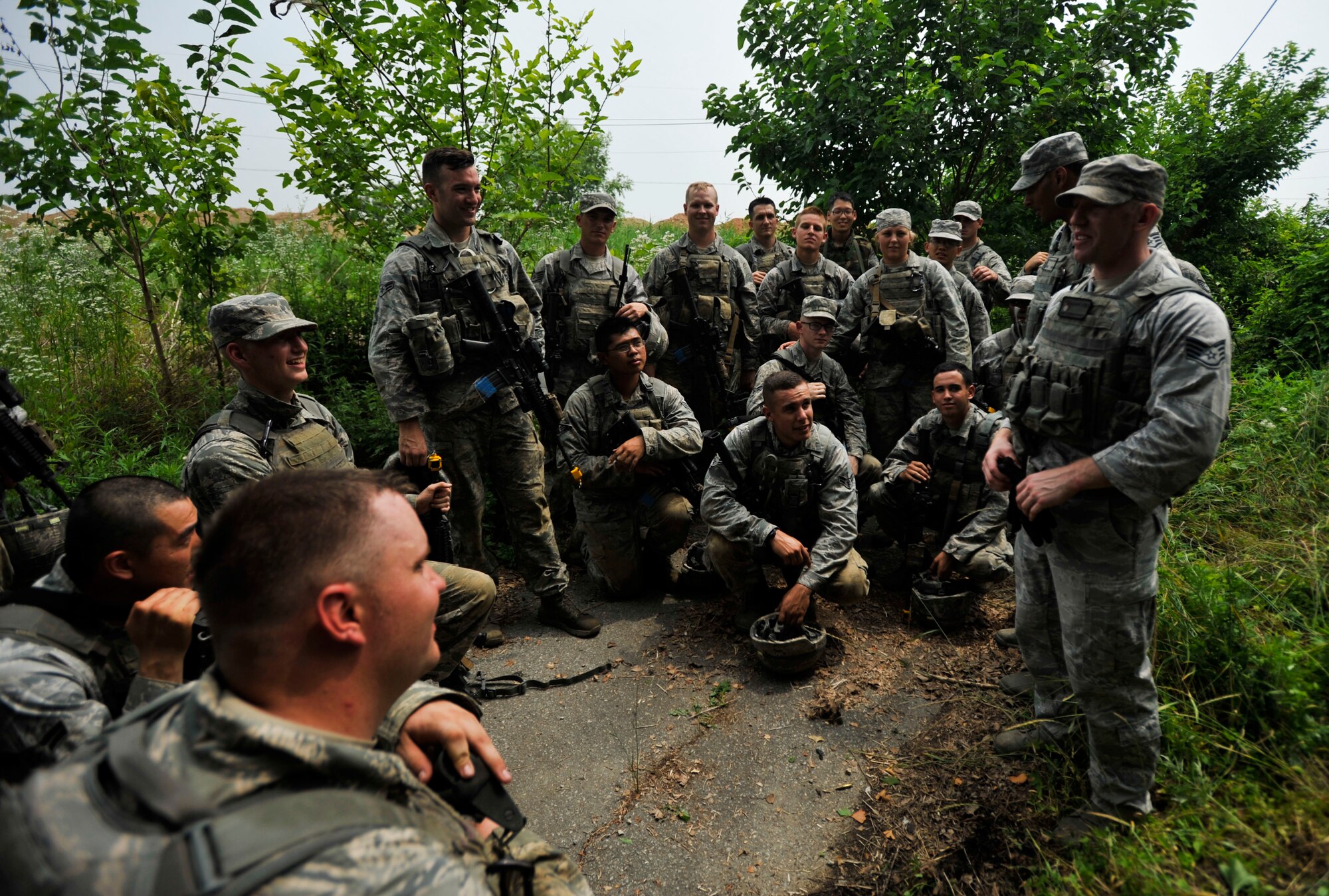 Staff Sgt. Devin Banks, 51st Security Forces Squadron training instructor, right, debriefs 51st SFS members after completing a field training exercise during a combat readiness course in an abandoned village in Pyeongtaek, Republic or Korea, June 20, 2014. The Airmen graduated the CRC on June 20. (U.S. Air Force photo/Senior Airman David Owsianka)