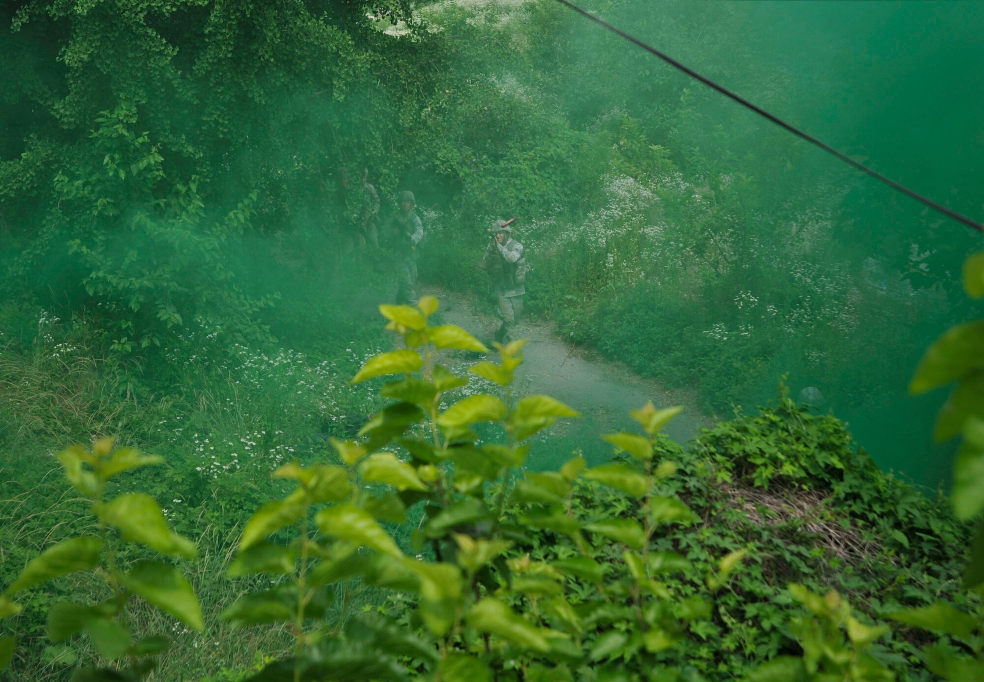 Members of the 51st Security Forces Squadron move toward a building full of mock opposition forces during a field training exercise as part of a combat readiness course in an abandoned village in Pyeongtaek, Republic or Korea, June 20, 2014. The Airmen use the tactics learned during the first four days of training to successfully complete the FTX. (U.S. Air Force photo/Senior Airman David Owsianka)