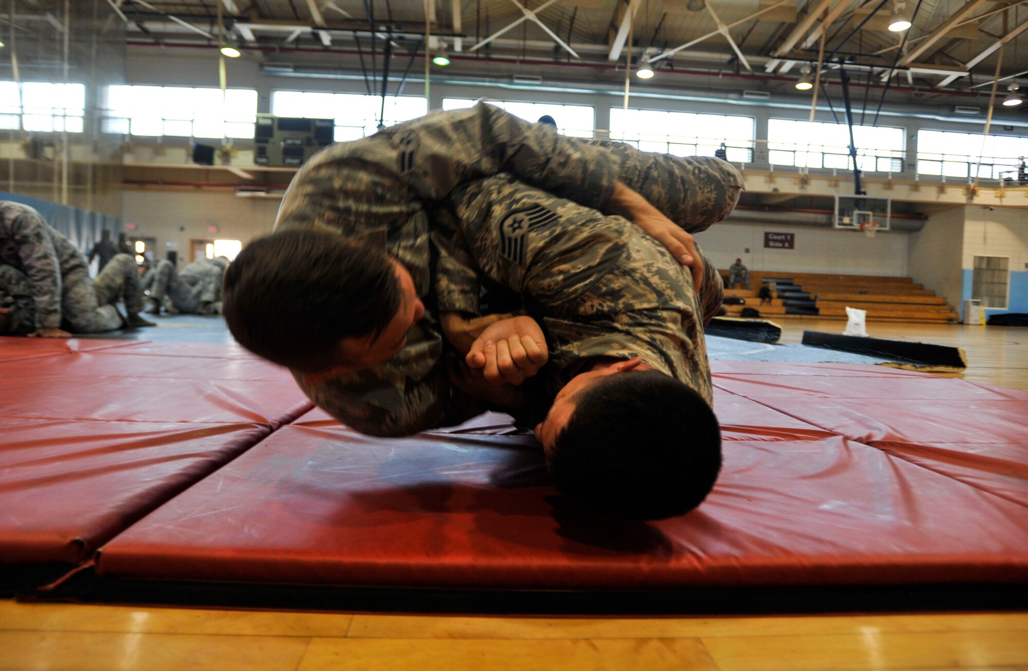 Staff Sgt. Justin Hains, 51st Security Forces Squadron member, performs a passing guard into side control move on Airman 1st Class Davis McMillen, 51st SFS member, during combatives training as part of a combat readiness course on Osan Air Base, Republic of Korea, June 19, 2014. Participants also learned how to use the Armament Systems and Procedures baton. (U.S. Air Force photo/Senior Airman David Owsianka)