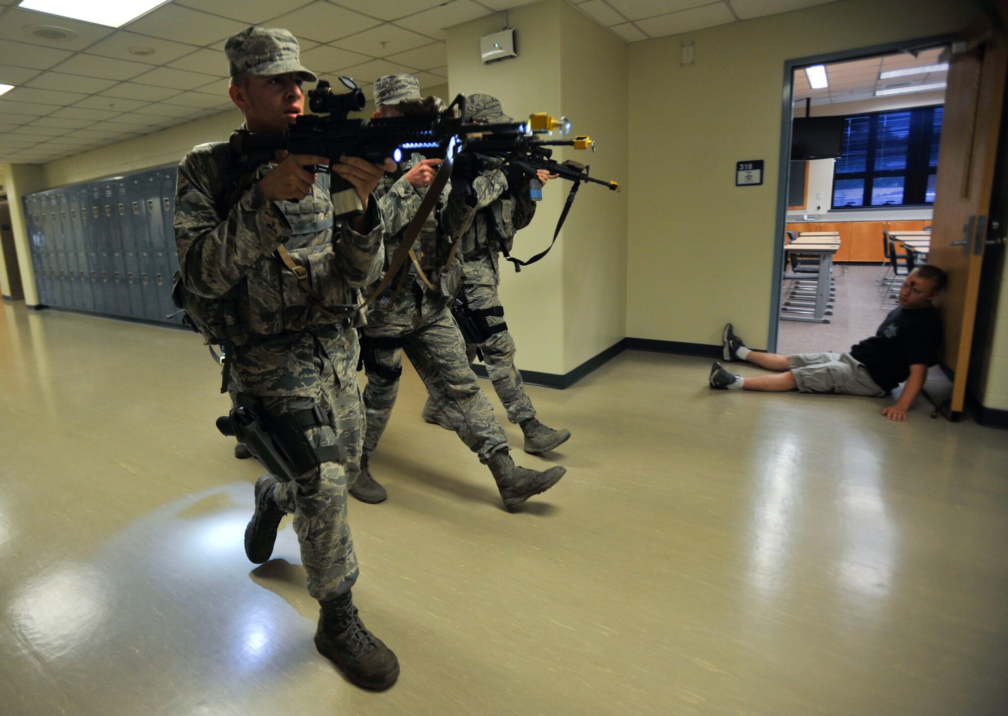 Members of the 51st Security Forces Squadron search an Osan Middle School hallway in pursuit of the active shooter during a combat readiness course exercise on Osan Air Base, Republic of Korea, June 18, 2014. The active shooter scenarios became more challenging as the exercise went on. (U.S. Air Force photo/Senior Airman David Owsianka)