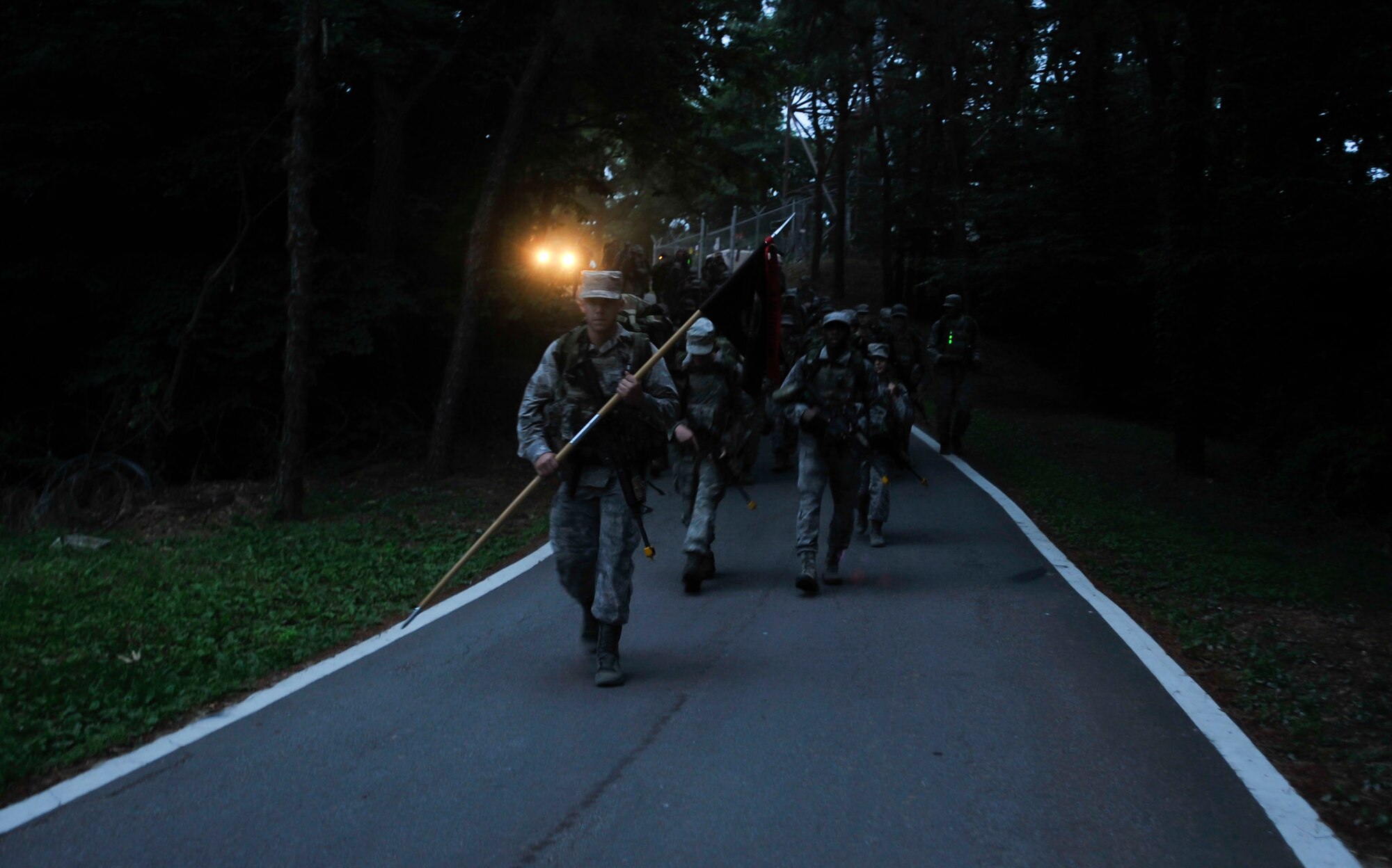 Airman 1st Class Nicholas Diamond, 51st Security Forces Squadron, holds the guidon as he leads Airmen during the ruck march on Osan Air Base, Republic of Korea, June 17, 2014. Airmen also performed dead body searches, ability to survive and operate, and mounted and dismounted training. (U.S. Air Force photo/Senior Airman David Owsianka)
