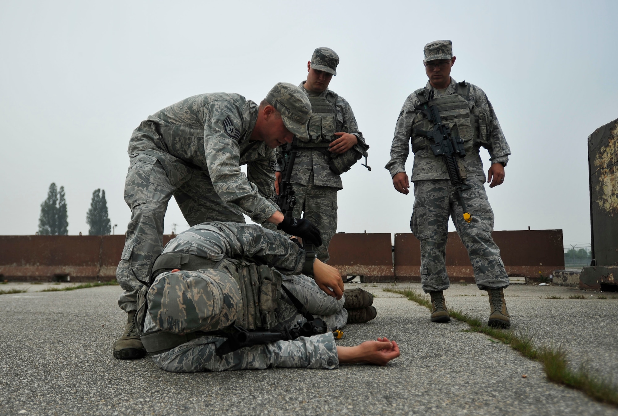 Staff Sgt. Devin Banks, 51st Security Forces Squadron training instructor, demonstrates how to reposition a body by using available material during dead body search training as part of a combat readiness course on Osan Air Base, Republic of Korea, June 17, 2014. Using available material to expose the body allows Airmen to conduct a proper body search. (U.S. Air Force photo/Senior Airman David Owsianka)
