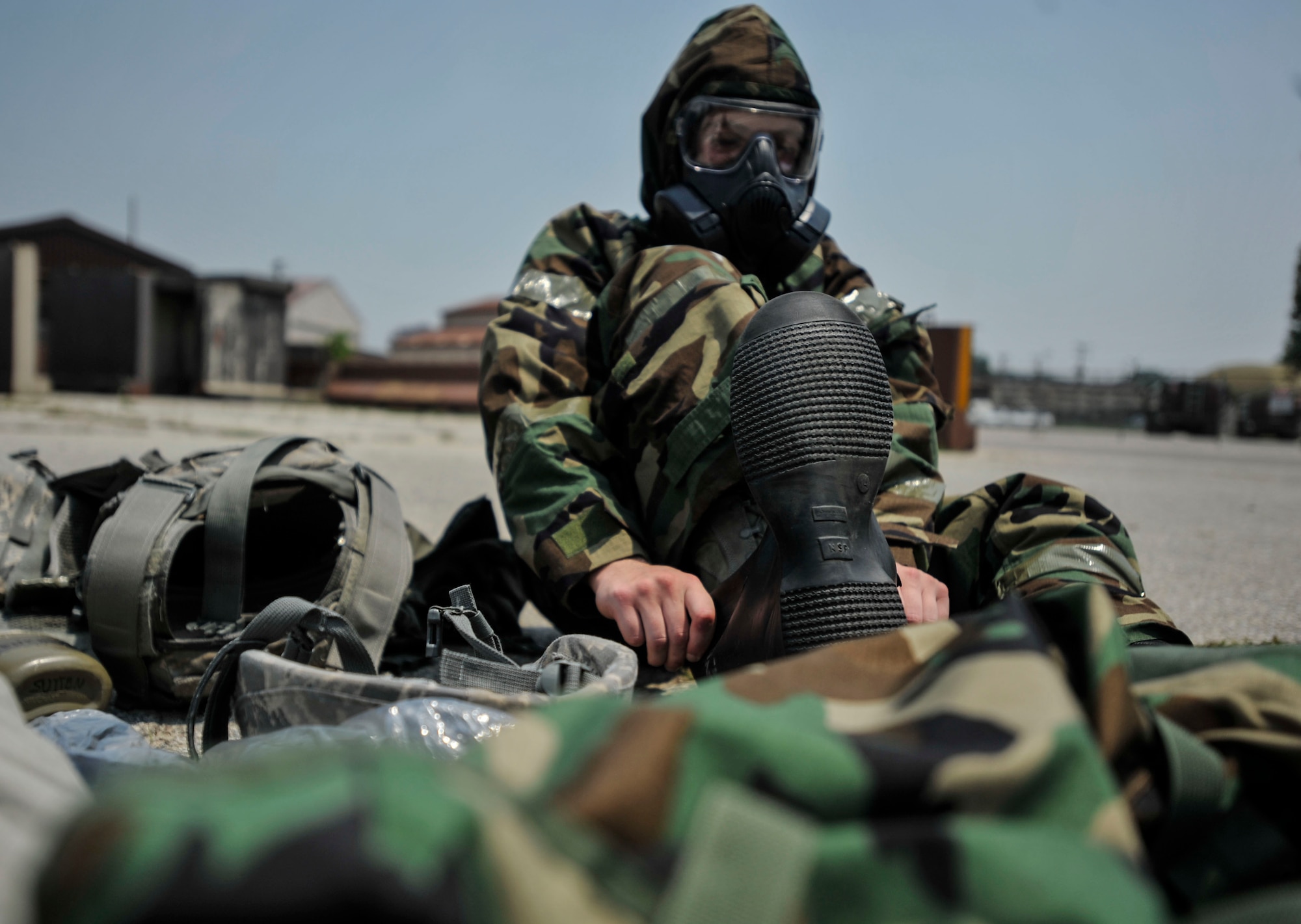 Airman 1st Class Nicholas Diamond, 51st Security Forces Squadron, dons Mission Oriented Protective Posture overboots during the ability to survive and operate training portion of a combat readiness course on Osan Air Base, Republic of Korea, June 16, 2014. MOPP gear is used by military personnel to protect themselves in potentially toxic environments. (U.S. Air Force photo/Senior Airman David Owsianka)