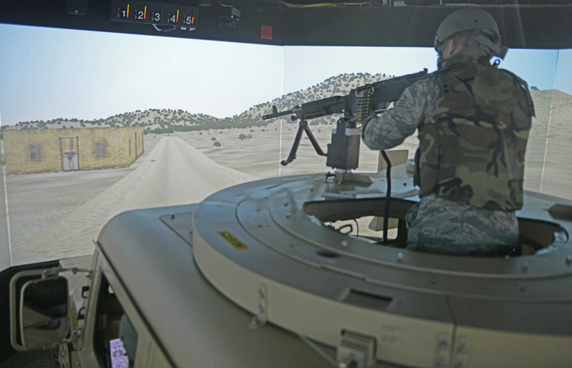 Senior Airman Jonathan Buenrostro, 673d Contracting Squadron contract specialist, operates a High Mobility Multipurpose Wheeled Vehicle mounted turret  during the Reconfigurable Vehicle Tactical Trainer program on Joint Base Elmendorf-Richardson, Alaska, June 18, 2014. The RVTT allows Soldiers to train in virtual environments similar to Afghanistan and other deployed locations with the use of animated 3D visualizations. (U.S. Air Force photo/Airman 1st Class Ty-Rico Lea)